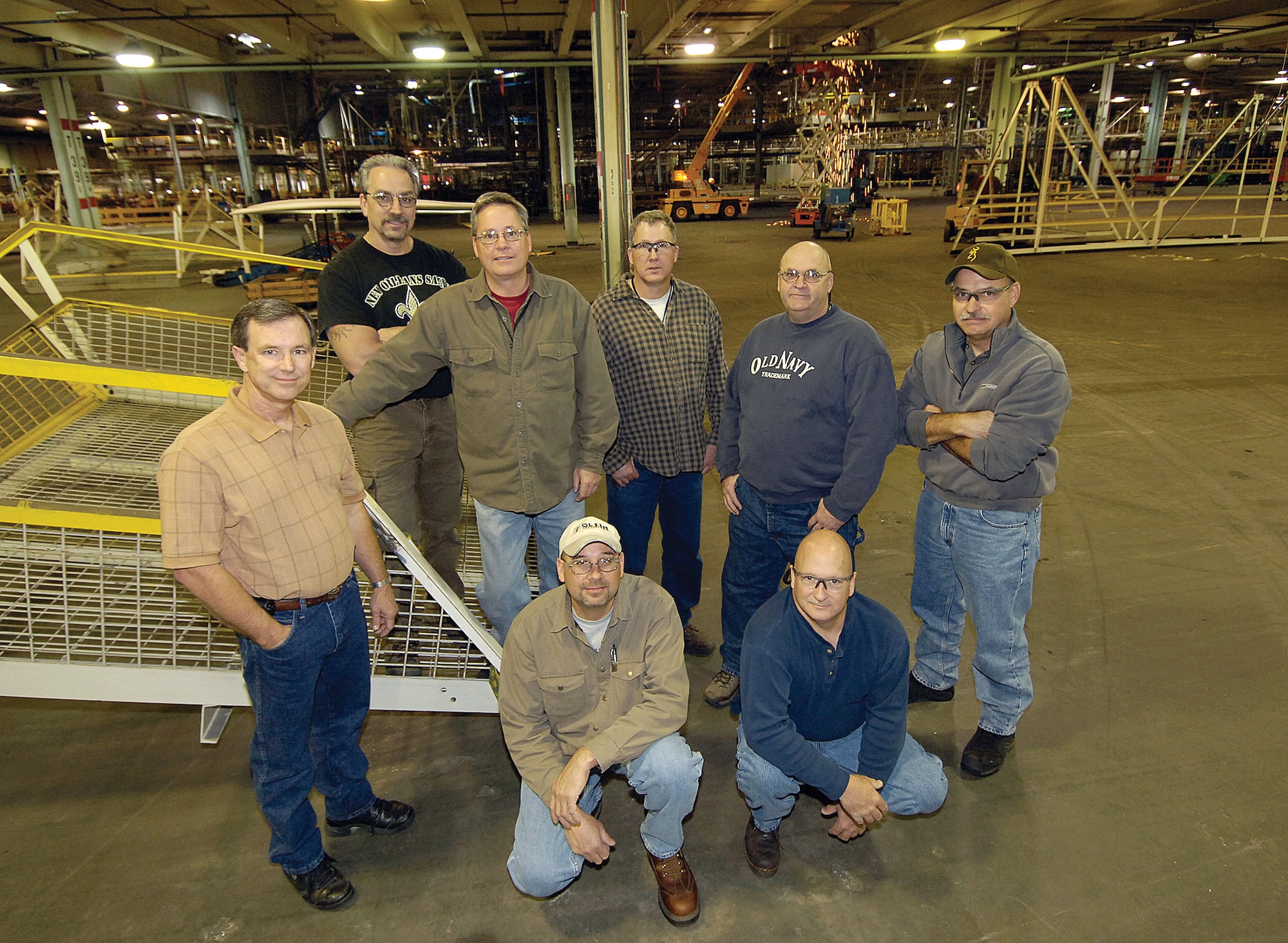 For several former General Motors employees now working at Tinker, the signing of the lease allowing the base to use the old GM plant will mean many will return to their old turf. Shown in the future TF-33 area of the 3-million square foot plant as Tinker crews remove old conveyor systems behind them are, from left; Mike Collum, Kenneth Cuff, Paul West, Danny Householder, Daryl Doss and William King.  Kneeling are Carl Jefferson, left, and Alan Garrison. (Air Force photo/Margo Wright)