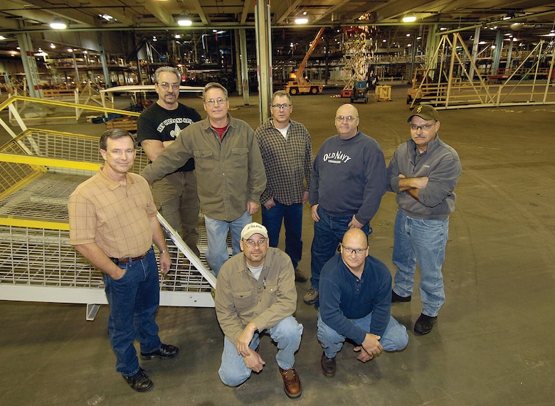 For several former General Motors employees now working at Tinker, the signing of the lease allowing the base to use the old GM plant will mean many will return to their old turf. Shown in the future TF-33 area of the 3-million square foot plant as Tinker crews remove old conveyor systems behind them are, from left; Mike Collum, Kenneth Cuff, Paul West, Danny Householder, Daryl Doss and William King.  Kneeling are Carl Jefferson, left, and Alan Garrison. (Air Force photo/Margo Wright)