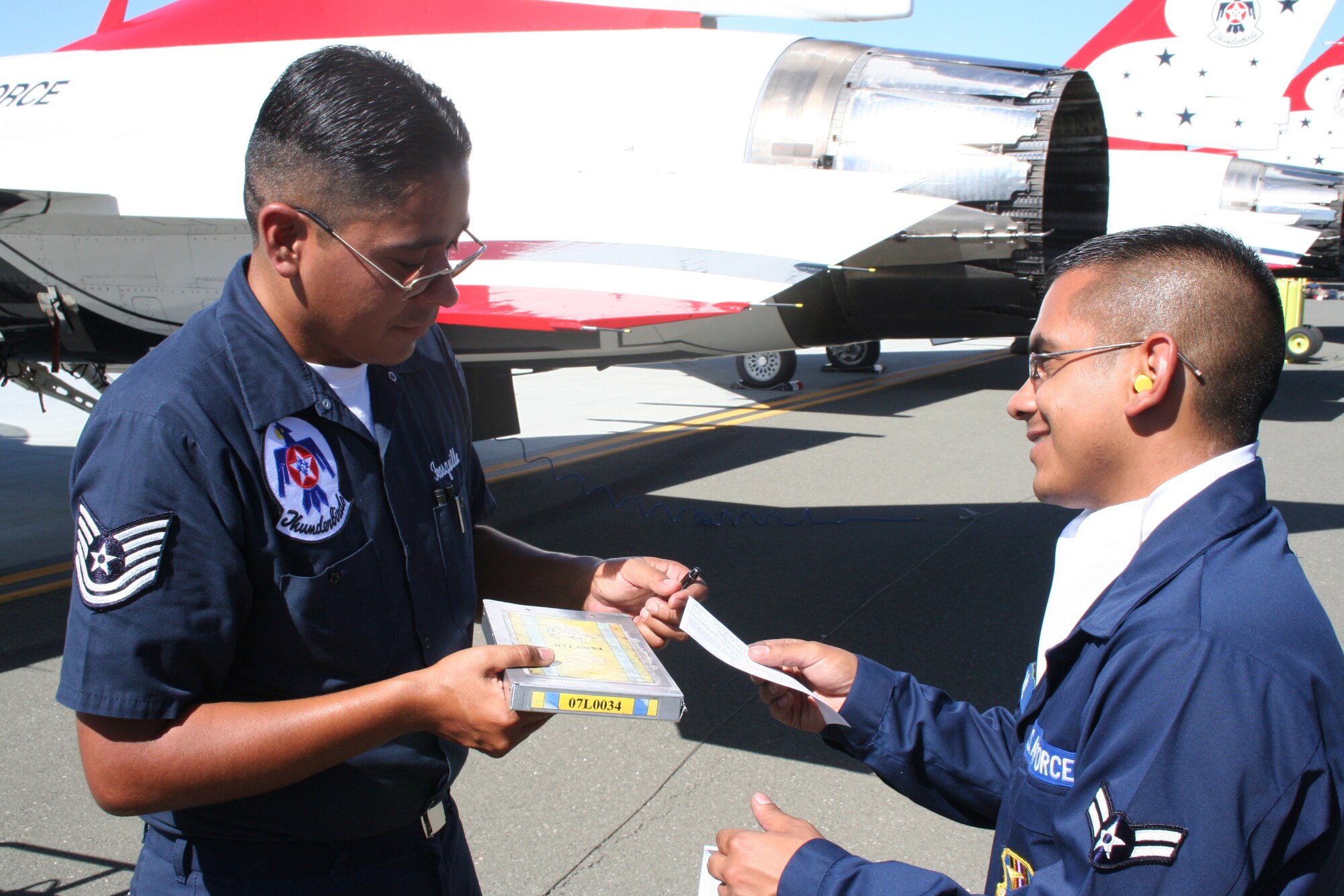 Airman 1st Class Adam Sanchez, 60th Logistics Readiness Squadron fuels operations technician, gives a USAF Thunderbirds crew chief his copy of fuel transaction paperwork at the 2008 Travis Air Expo. (U.S. Air Force photo/Tech. Sgt. Matthew Painter)
