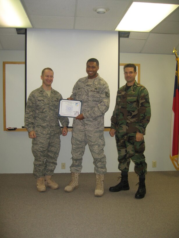 SEYMOUR JOHNSON AIR FORCE BASE, N.C. -- Tech. Sgt. Bobby Moore (center), 916th Civil Engineer power production technician, receives his promotion certificate from Capt. Chris Woofter (left), squadron commander and Tech. Sgt.  Eric Mazur, supervisor.
