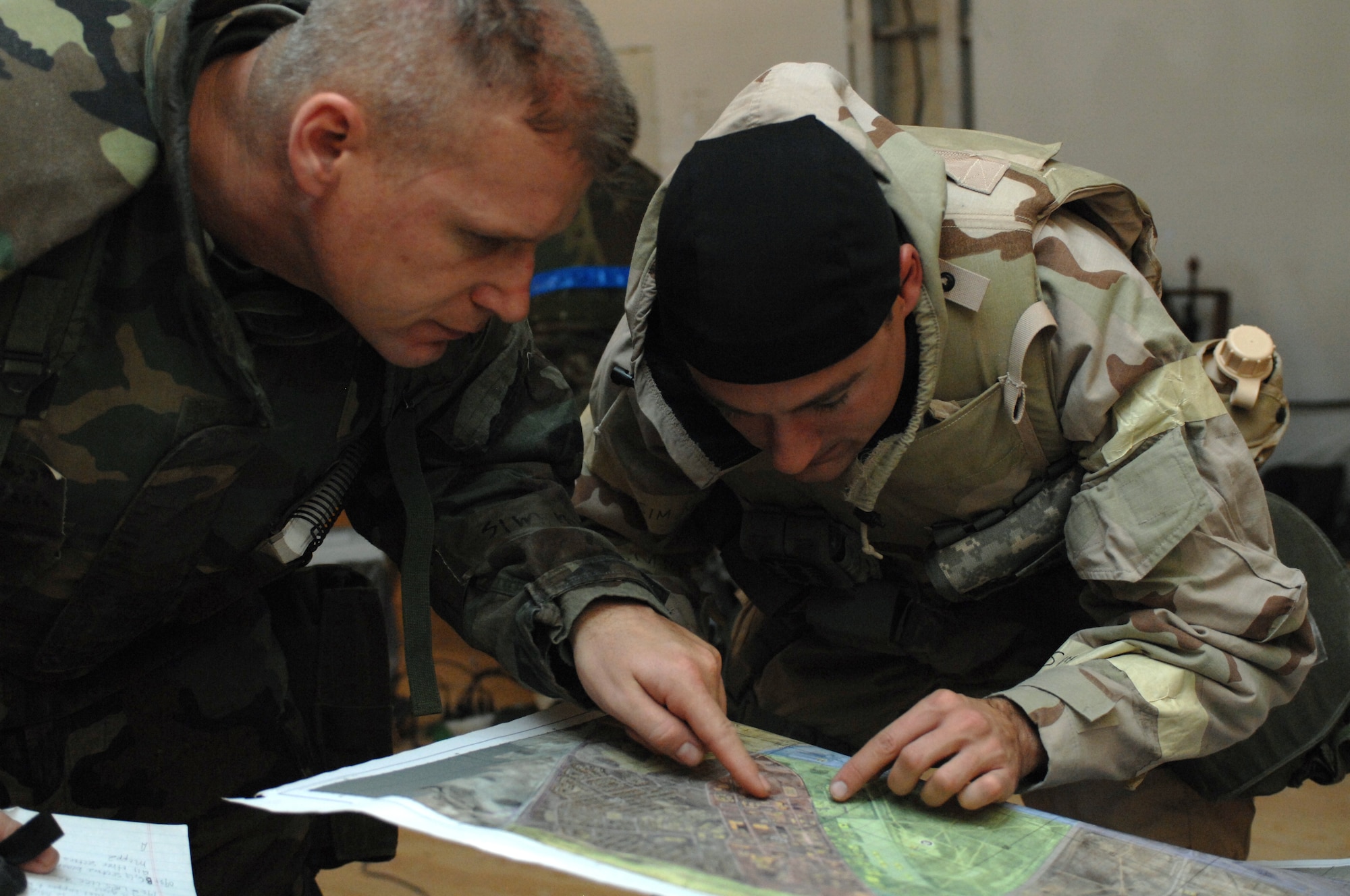 Senior Master Sgt. Ed Lukitsch and Capt. Daniel Werner, both from the 49th Civil Engineer Squadron, search for a particular location on a map while manning the Tactical Operations Center (TOC) at the CE pit during a phase II exercise at Holloman Air Force Base, N.M., Nov. 19. This is the first exercise that the 49 CES utilized a TOC instead of a Damage Control Center (UCC) during an exercise, due to the squadrons recent tasking with the U.S. Northern Command?s dedicated response force. (U.S. Air Force photo/Airman Sondra M. Escutia)