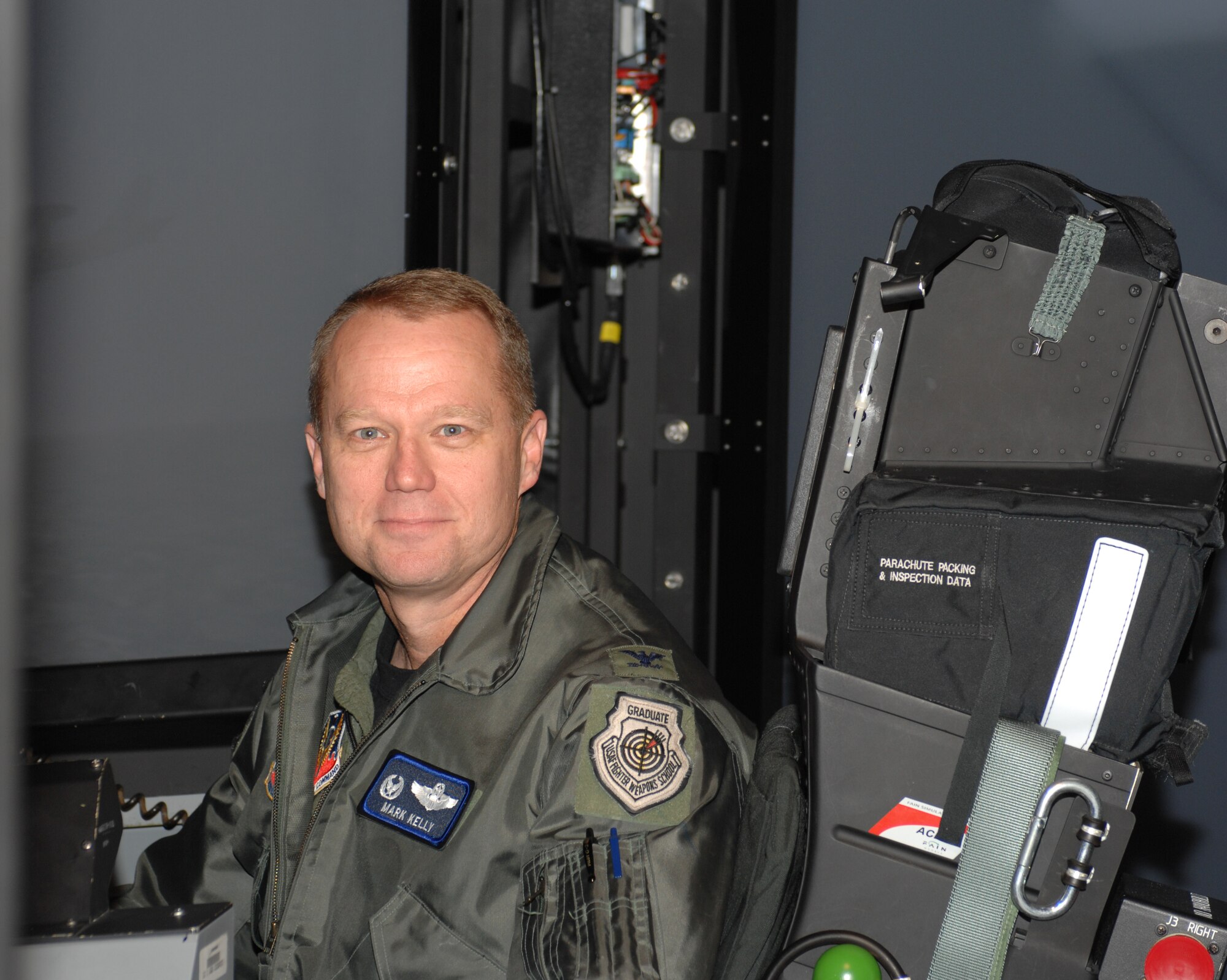 Base commander Col. Mark D. Kelly sits in a mission training center Nov. 14 at Seymour Johnson Air Force Base, N.C. A mission training center is a flight simulator where aircrews can practice real-life scenarios without the cost of fuel or the potential of danger. (U.S. Air Force photo by Airman 1st Class Gino Reyes)