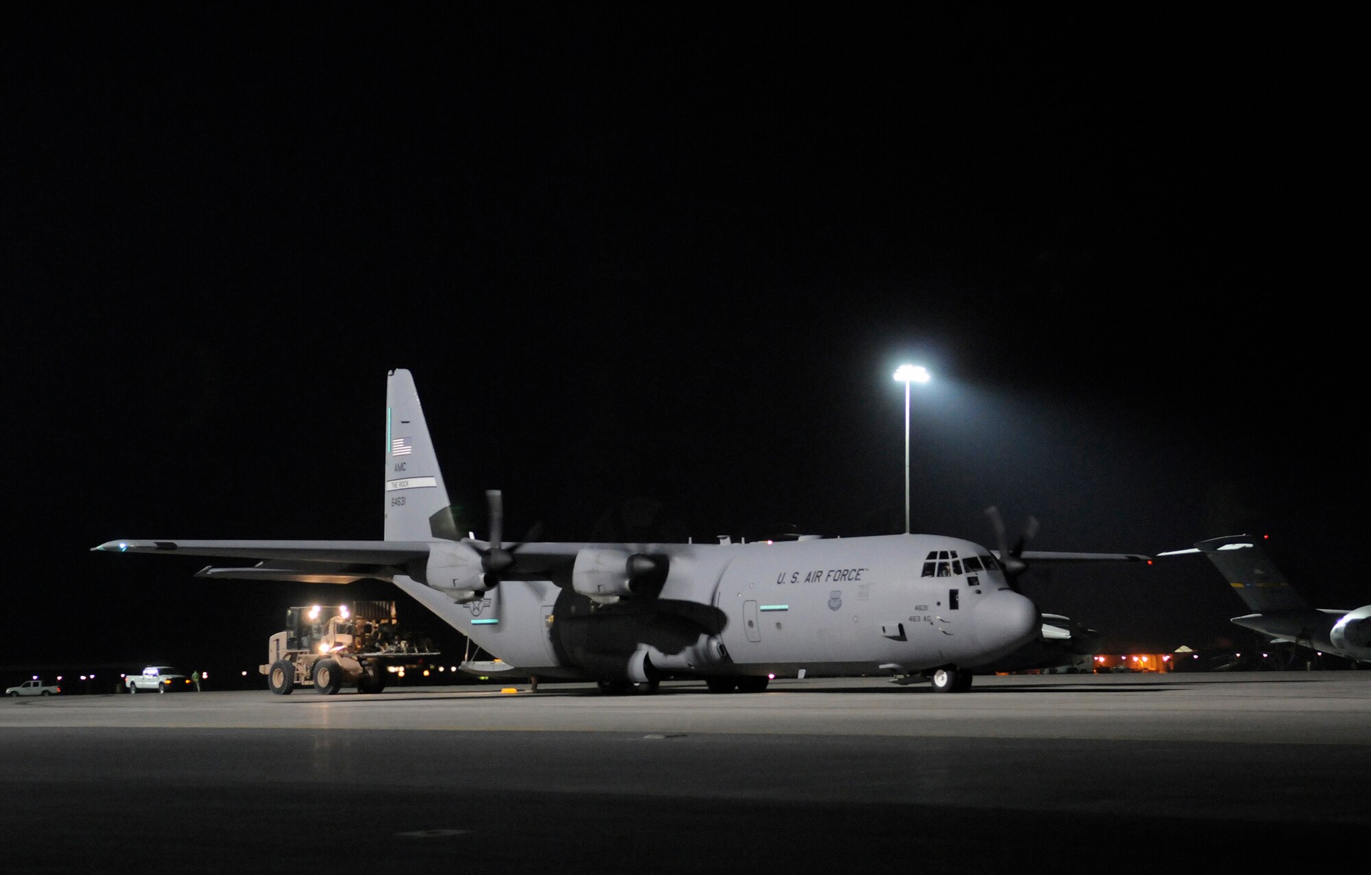 A C-130 Hercules is uploaded with increased safety and security from stadium lights on 120-foot masts, Nov. 17, at this undisclosed air base in Southwest Asia.  A total of 50 lights on 5 masts, bring safe lighting to the Central Command Area of Responsibility's busiest aerial port, in support of Operations Iraqi and Enduring Freedom and Joint Task Force-Horn of Africa.  (U.S. Air Force photo by Tech. Sgt. Michael Boquette/Released)