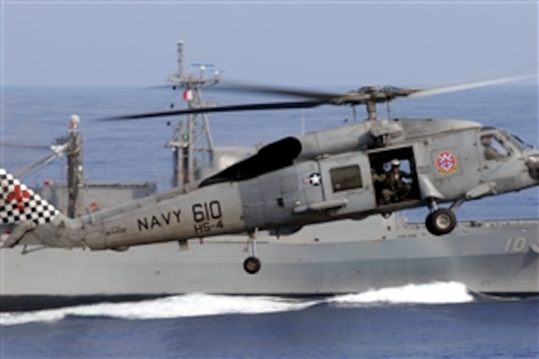 U.S. Navy Petty Officer 2nd Class Jeremy Thomas looks out the door of an SH-60F Sea Hawk assigned to the "Black Knights" of Helicopter Anti-Submarine Squadron 4 during an ammo offload between the Military Sealift Command fast combat support ship USNS Bridge and the Nimitz-class aircraft carrier USS Ronald Reagan, Pacific Ocean, Nov. 14, 2008. The USS Ronald Reagan is on a routine deployment, currently operating in the U.S. 7th Fleet area of responsibility.