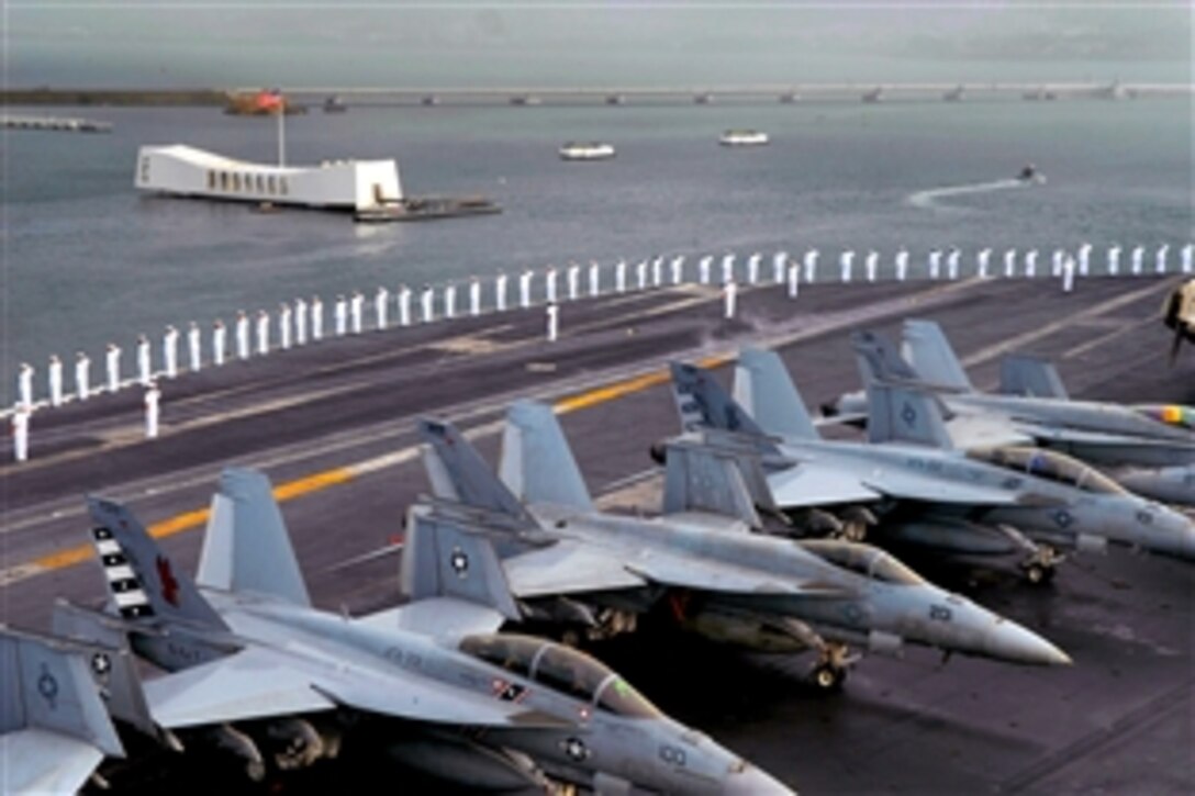 U.S. Navy sailors man the rails on the flight deck of the aircraft carrier USS Ronald Reagan as they pass by the USS Arizona memorial in Pearl Harbor, Hawaii, Nov. 17, 2008. Ronald Reagan pulled into Pearl Harbor for a scheduled port visit.