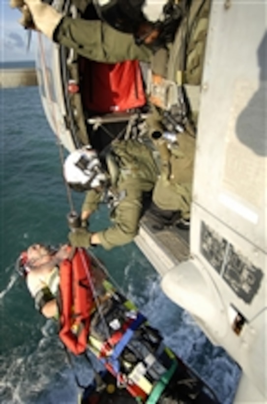 U.S. Navy Petty Officer 2nd Class Zachary Gillespie and Petty Officer 3rd Class Phillip Gonzales hoist a Norwegian man from the ocean-going tug SVC Tanux II during a search and rescue medical evacuation while underway in the Atlantic Ocean on Nov. 12, 2008.  The sailors are responding to an emergency medical distress call received while supporting the Caribbean phase of the humanitarian and civic assistance mission Continuing Promise 2008.  Both men are assigned to Detachment 5, Helicopter Sea Combat Squadron 28, and embarked aboard the amphibious assault ship USS Kearsarge (LHD 3).  