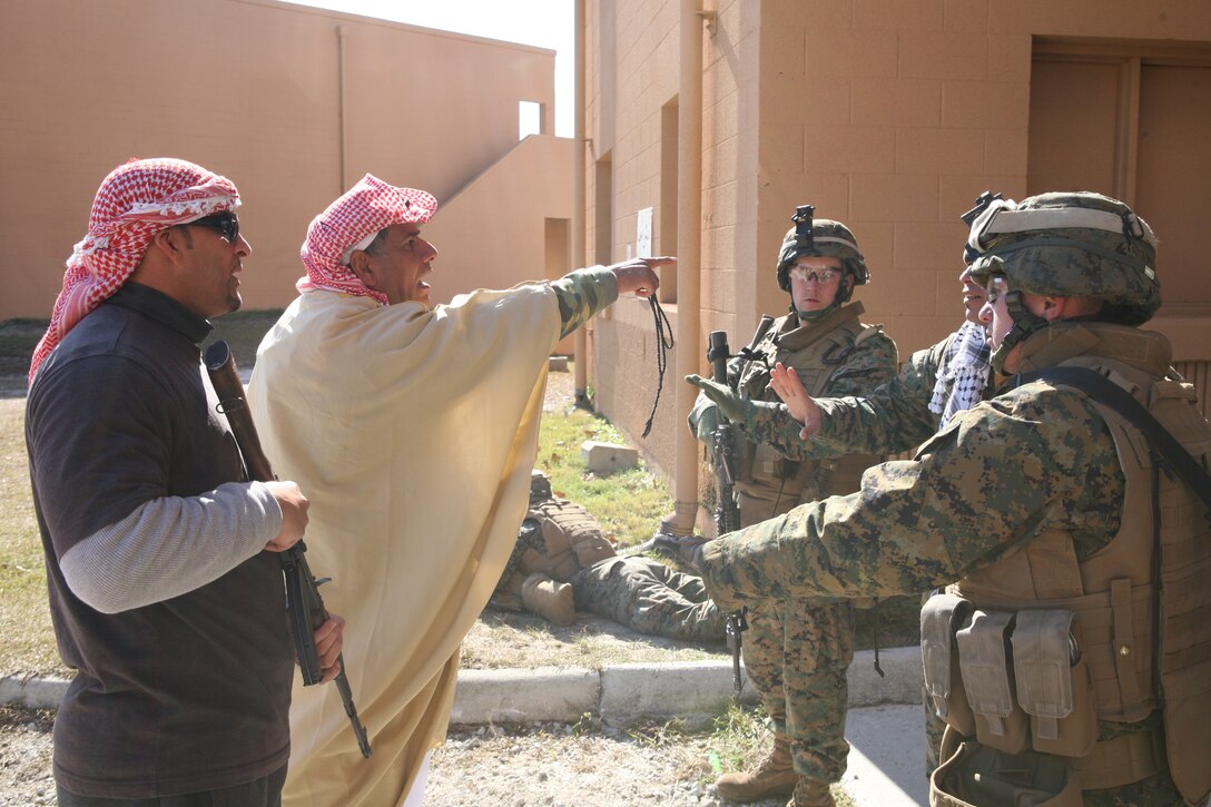 Marines from Bravo Company, 1st Battalion, 8th Marine Regiment, 2nd Marine Division, speak with an Iraqi role-player acting as a local sheik following an attack on a vehicle checkpoint.  The military operations in urban terrain facility was used as part of a week-long battalion field exercise in preparation for the battalion’s deployment in support of Operation Iraqi Freedom.