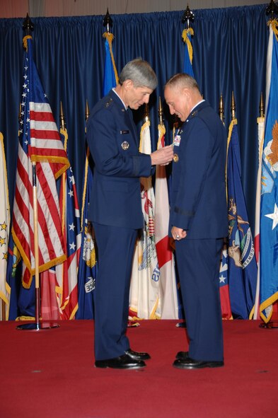 Air Force Chief of Staff Gen. Norton Schwartz pins the Distinguished Service Medal on Gen. Bruce Carlson, former commander of Air Force Materiel Command. General Carlson relinquished his position during a change-of-command ceremony Nov. 21 at the National Museum of the United States Air Force at Wright-Patterson Air Force Base, Ohio. With his retirement, General Carlson caps nearly 38 years of service in the Air Force, the last three of which he spent as the AFMC commander. (Air Force photo by Ben Strasser) 