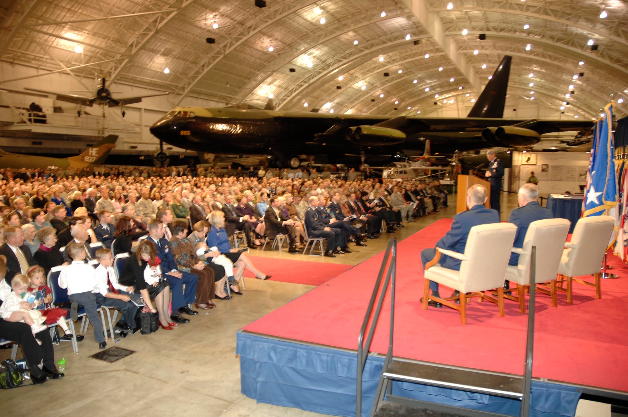 A B-52 Stratofortress stands silent guard behind the crowd gathered for a change of command ceremony Nov. 21 in the Modern Flight Gallery of the National Museum of the United States Air Force at Wright-Patterson Air Force Base, Ohio.  The ceremony, which is steeped in military history and tradition, marked the passing of leadership of Air Force Materiel Command from Gen. Bruce Carlson to Gen. Donald Hoffman.  As AFMC commander, is responsible for providing the acquisition management services and logistics support required to develop, procure and sustain Air Force weapon systems. (U.S. Air Force photo/Ben Strasser)