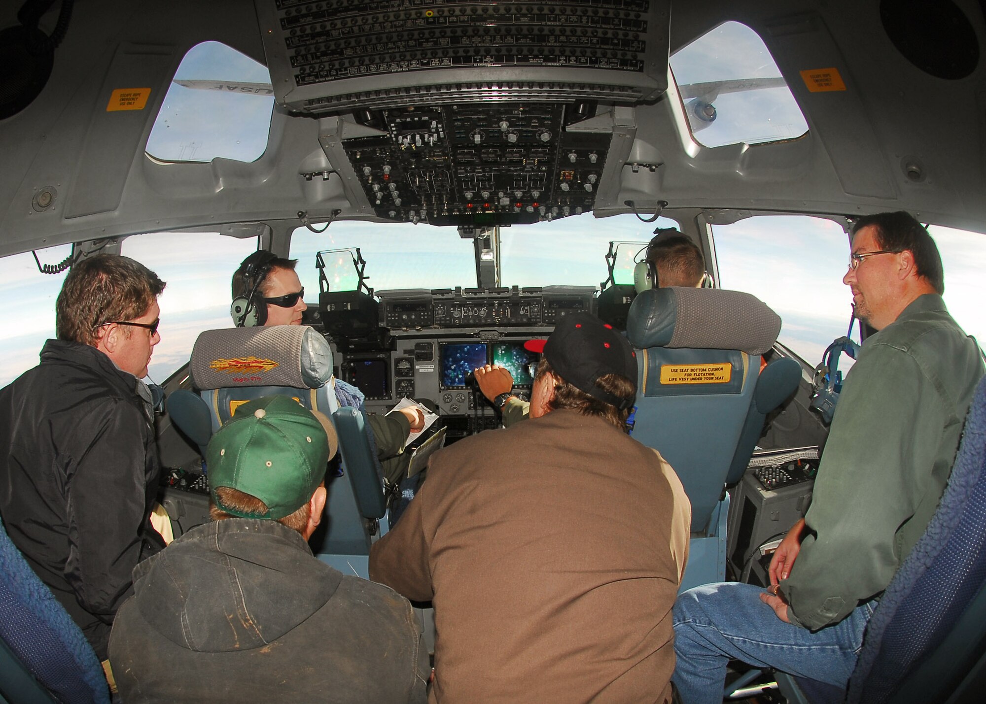 Capt. Wesley Skenfield answers questions as Capt. Aaron Gibbs lines up their C-17 Globemaster III for refueling by the KC-135 Stratotanker visible in the upper windows.  The passengers are neighbors of Altus Air Force Base, Okla., and were part of a Farm-City community outreach program orientation flight Nov. 14.   (U.S. Air Force photo/Senior Airman Amanda M. Bower) 