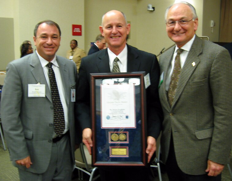 Nelson Escribano ( center), recipient of the Golden Talon Award at the 2nd Annual Service-Disabled Veteran-Owned Small Business Program Awards Ceremony, is flanked by Ronald A. Poussard (left), the director of the Secretary of the Air Force Small Business Programs, and James I. Finley, deputy under secretary of defense for acquisition and technology.  Mr. Escribano is the small business specialist at the 6th Air Mobility Wing, MacDill Air Force Base, Fla. The award ceremony was held at the Pentagon Conference Center Nov. 17. (Courtesy photo/CorpComm Inc.) 