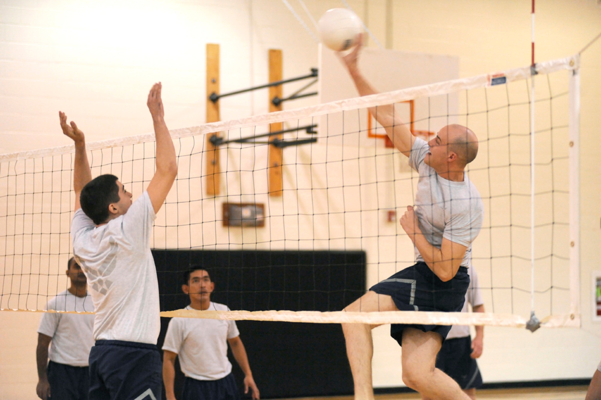 An Airman spikes the ball over the net at a volleyball game during Wingman Day Nov. 21 at the fitness center. McGuire units competed in sports like volleyball and basketball to build camaraderie between Airmen. Units also hosted discussions about professional development to remind Airmen to take care of each other. (U.S. Air Force photo/Carlos Cintron)