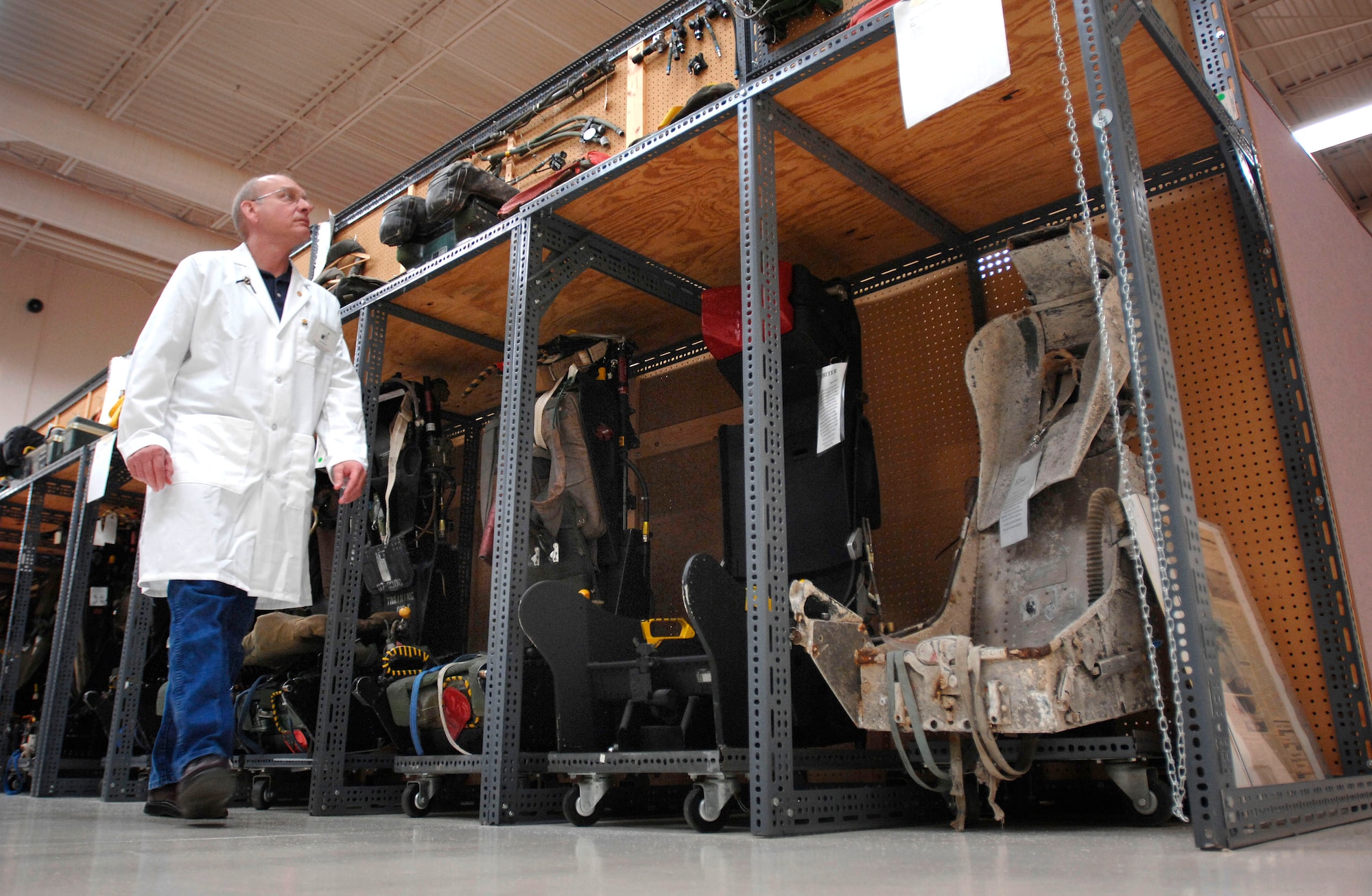 Equipment Analyst Jim Hodges walks past rows of ejection seats at the 21,000-square-foot Life Sciences Equipment Laboratory Nov. 4 at Brooks City-Base in San Antonio. The lab is home to more than 50,000 uniforms and pieces of equipment from as far back as World War I. About 250 ejection seats line the walls. (Department of Defense photo/Fred W. Baker III)
