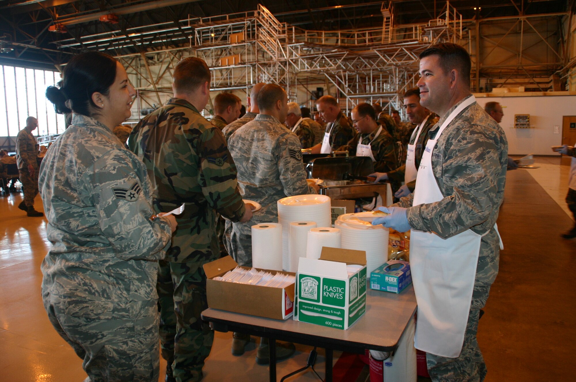Maj. Dwight Minnick, commander, 552nd Maintenance Operations Squadron starts off the MXG Turkey Feast by handing out plates and bread rolls. Photo compliments of 1st Lt. Kinder Blacke.