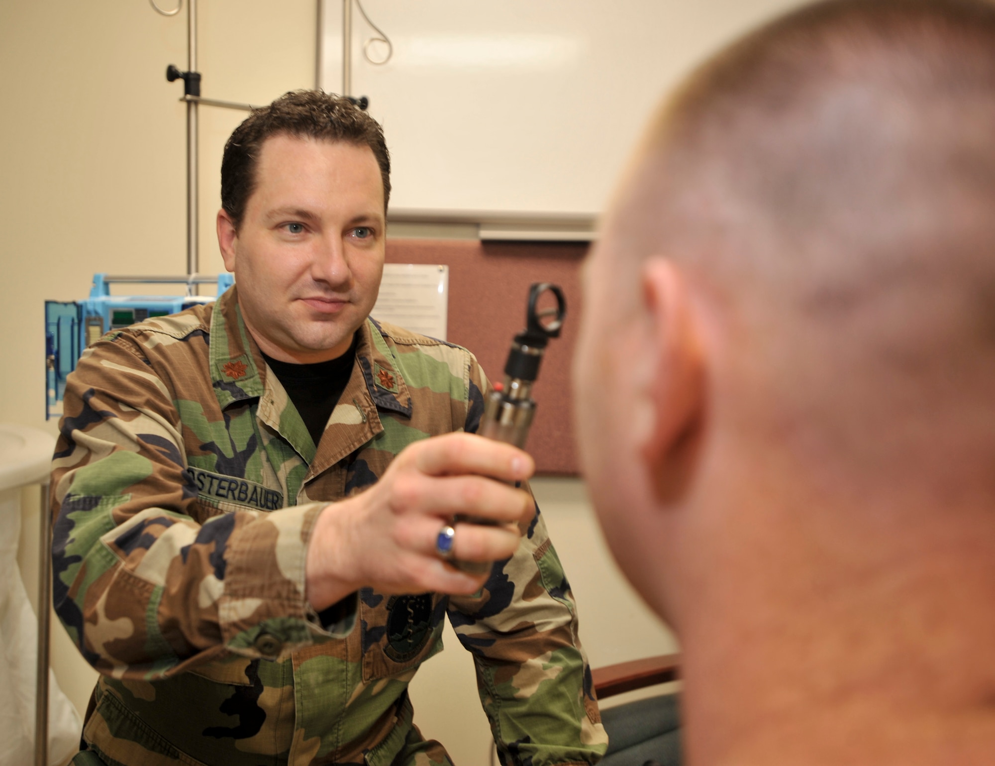 ELMENDORF AIR FORCE BASE, Alaska -- Maj. Peter Osterbauer, 3rd Medical Group chief of Neurology Services, uses a simple flash light tool to examine a patient's eyes in the Traumatic Brain Injury clinic Nov. 18. Major Osterbauer also uses an ophthalmoscope to see behind the eye and look at the brain for any swelling or busted blood vessels in the brain. (U.S. Air Force photo/Senior Airman Tinese Treadwell)