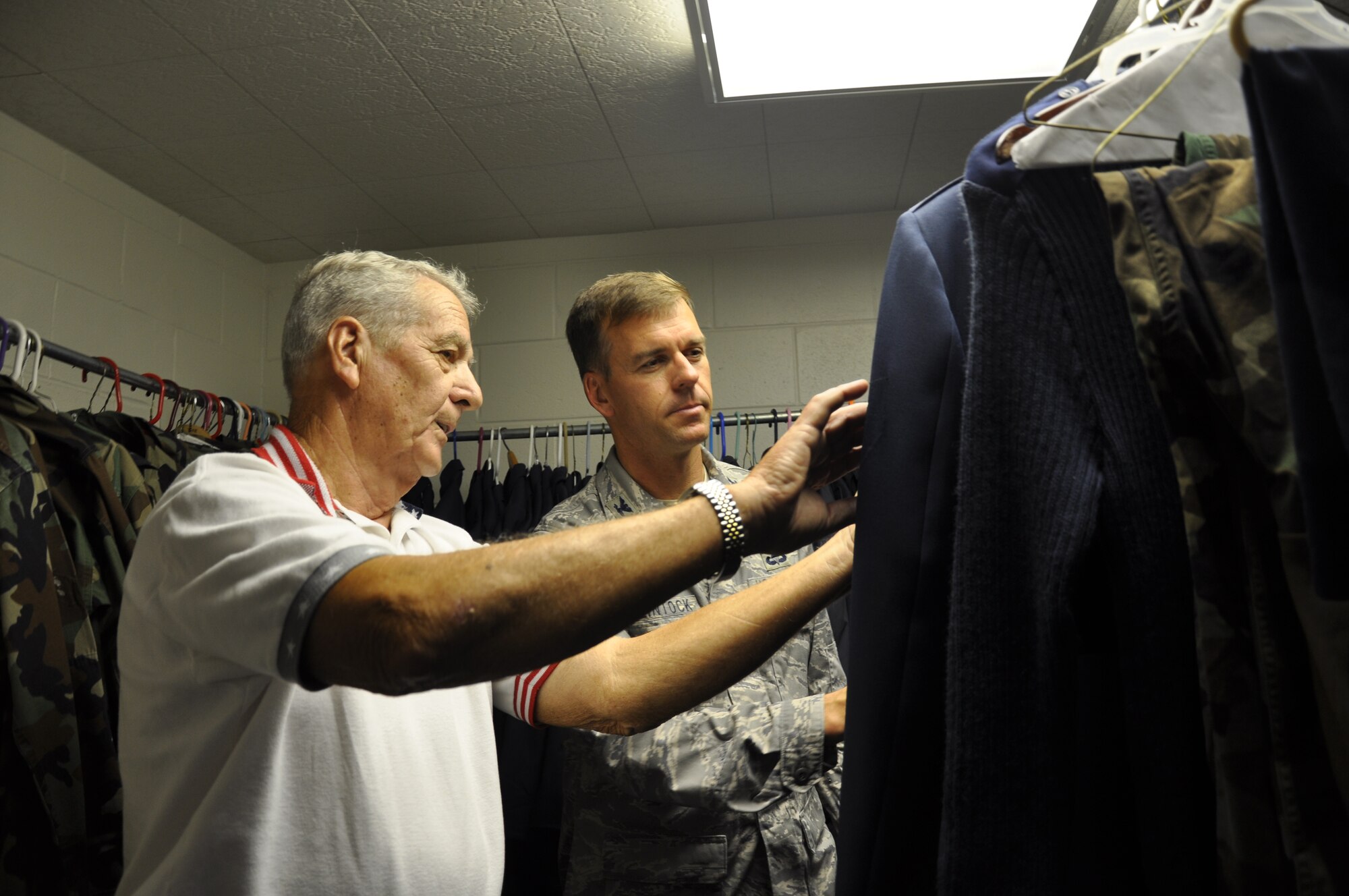 EGLIN AIR FORCE BASE, Fla. -- Bob White, Airman's Attic director, shows the military clothing section of the attic to Col. Bruce McClintock, 96th Air Base Wing commander, during a visit Nov. 14. Colonel McClintock presented Mr. White with a challenge coin after the tour for his efforts over the past years. (U.S. Air Force photo by Staff Sgt. LuCelia Ball)