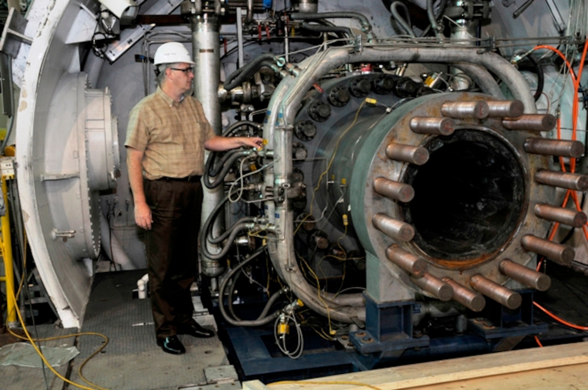 Dr. Lynn Sebourn, an Aerospace Testing Alliance facility systems analysis team engineer at Arnold Engineering Development Center, Arnold Air Force Base, Tenn., inspects the cooling water lines of the combustion air heater at the Aerodynamic and Propulsion Test Unit prior to a test run. (Photo by Rick Goodfriend)