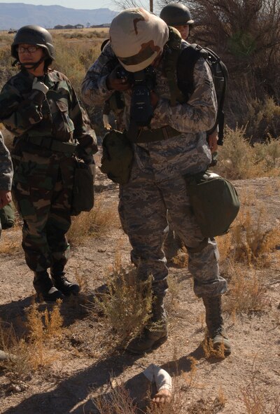 Airman 1st Class Deandre Curtiss, 49th Fighter Wing, participates in a search and recovery scenario at Holloman Air Force Base, N.M., Nov. 20. Airman Curtiss' role is to take photographs of all the remains and personal items found for documentation. Approximately 30 members from the 49th Fighter Wing were called to perform the simulated search and recovery during Exercise Coronet Gold Rush 08-08. (U.S. Air Force photo/Airman 1st Class Michael Means)