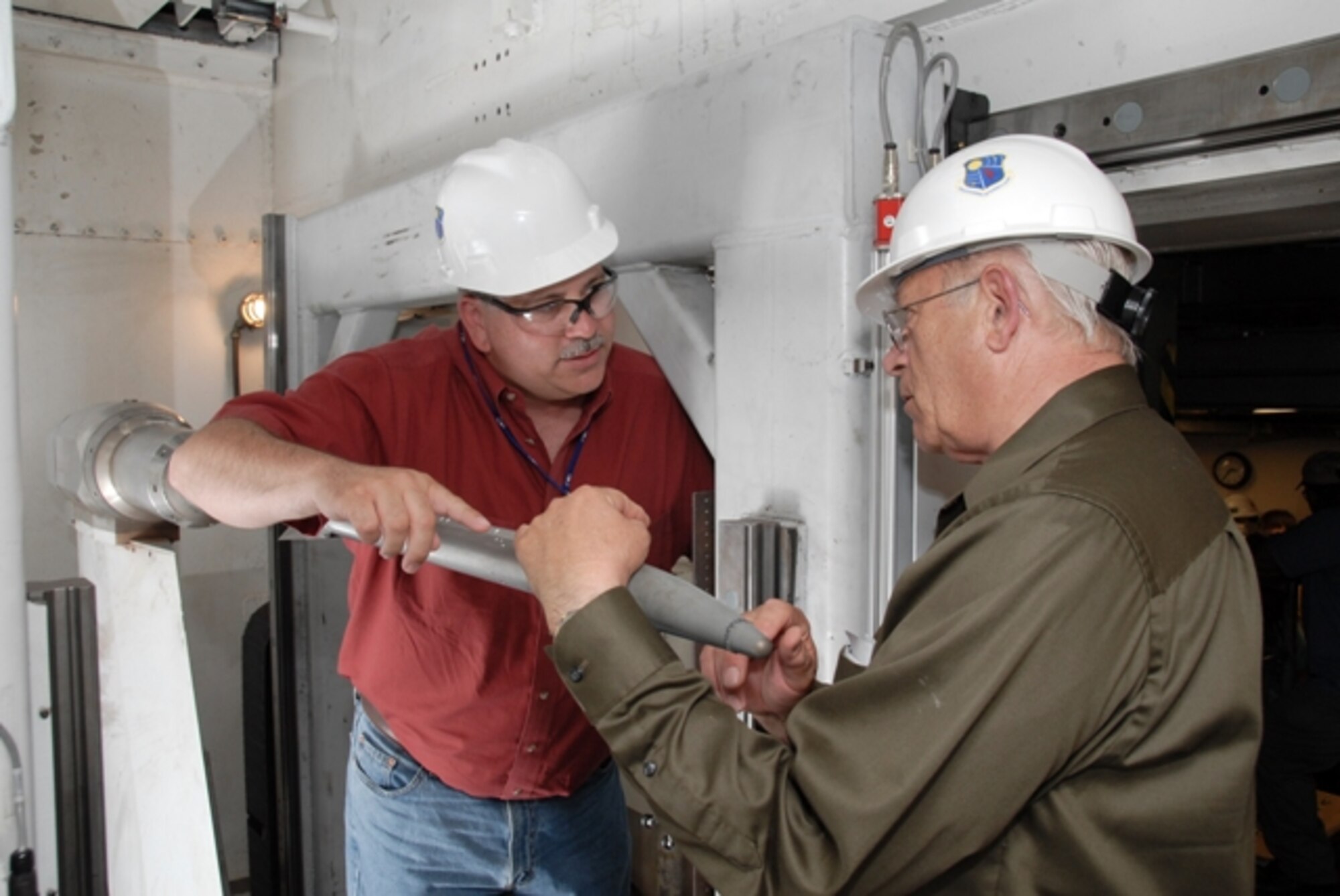 From left, Terry Finley, an engineer with Willbrook Solutions, the Missile Defense Agency support contractor providing aero and test engineering service, and David Carlson, lead test engineer with Raytheon, inspect the Stunner missile model between configuration changes during the testing in Arnold Engineering Development Center’s von Karman Gas Dynamics Facility Tunnel A. (Photo by Rick Goodfriend)