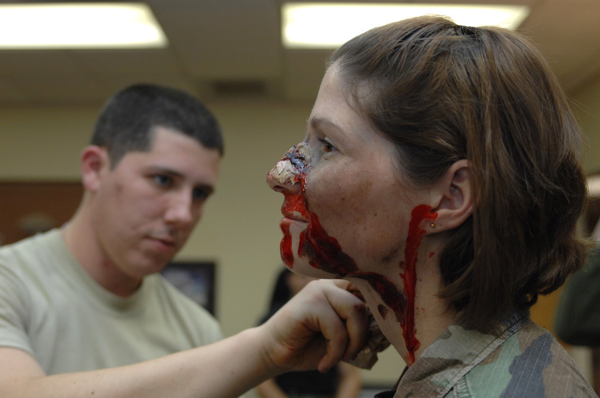 A member of the moulage team uses moulage make-up to make Airman 1st Class Janelle Hockman, 49th Medical Operations Squadron, into a simulated casualty to use in an explosion scenario during a phase II exercise at Holloman Air Force Base, N.M., Nov. 20. The moulage team made many members appear to be severely injured throughout the week-long exercise so Airmen can practice self-aid and buddy care skills in the most realistic manner possible. (U.S. Air Force photo/Airman Sondra M. Escutia)