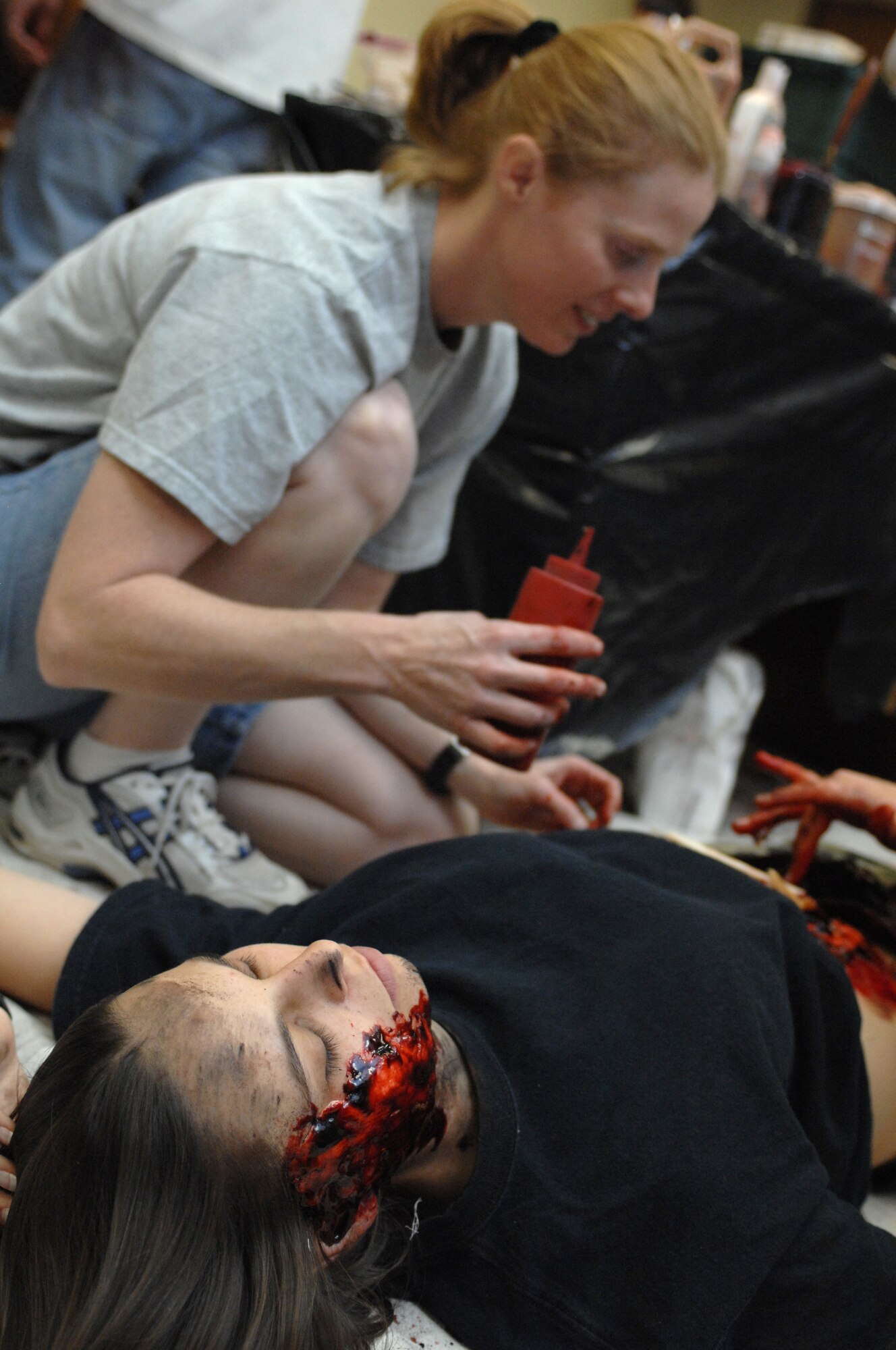 A member of the moulage team uses moulage make-up to make Senior Airman Nicole Thompson, 49th Operations Support Squadron, into a simulated casualty to use in an explosion scenario during a phase II exercise at Holloman Air Force Base, N.M., Nov. 20. The moulage team made many members appear to be severely injured throughout the week-long exercise so Airmen can practice self-aid and buddy care skills in the most realistic manner possible. (U.S. Air Force photo/Airman Sondra M. Escutia)