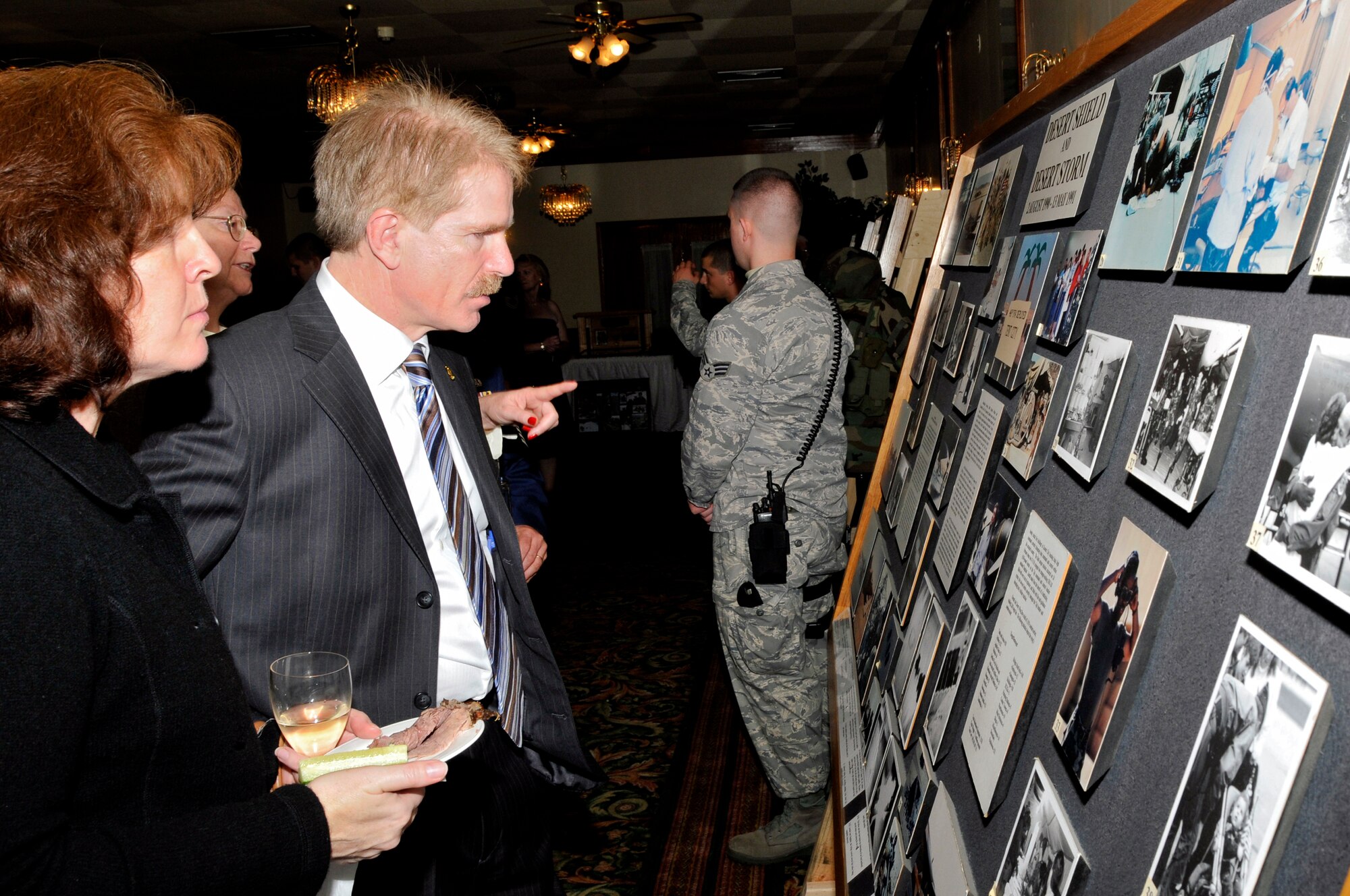 Howard Cook, honorary commander of the 493rd Fighter Squadron and his wife, Peta Cook, honorary commander  of the 48th Aerospace Medical Squadron, look at a story board of RAF Lakenheath's participation in Operation Desert Shield Nov 14 at RAF Lakenheath, England. The 48th Fighter Wing displayed the capabilities of the wing during the 60th anniversary of RAF Lakenheath. (U.S. Air Force photo by Airman 1st Class Perry Aston)