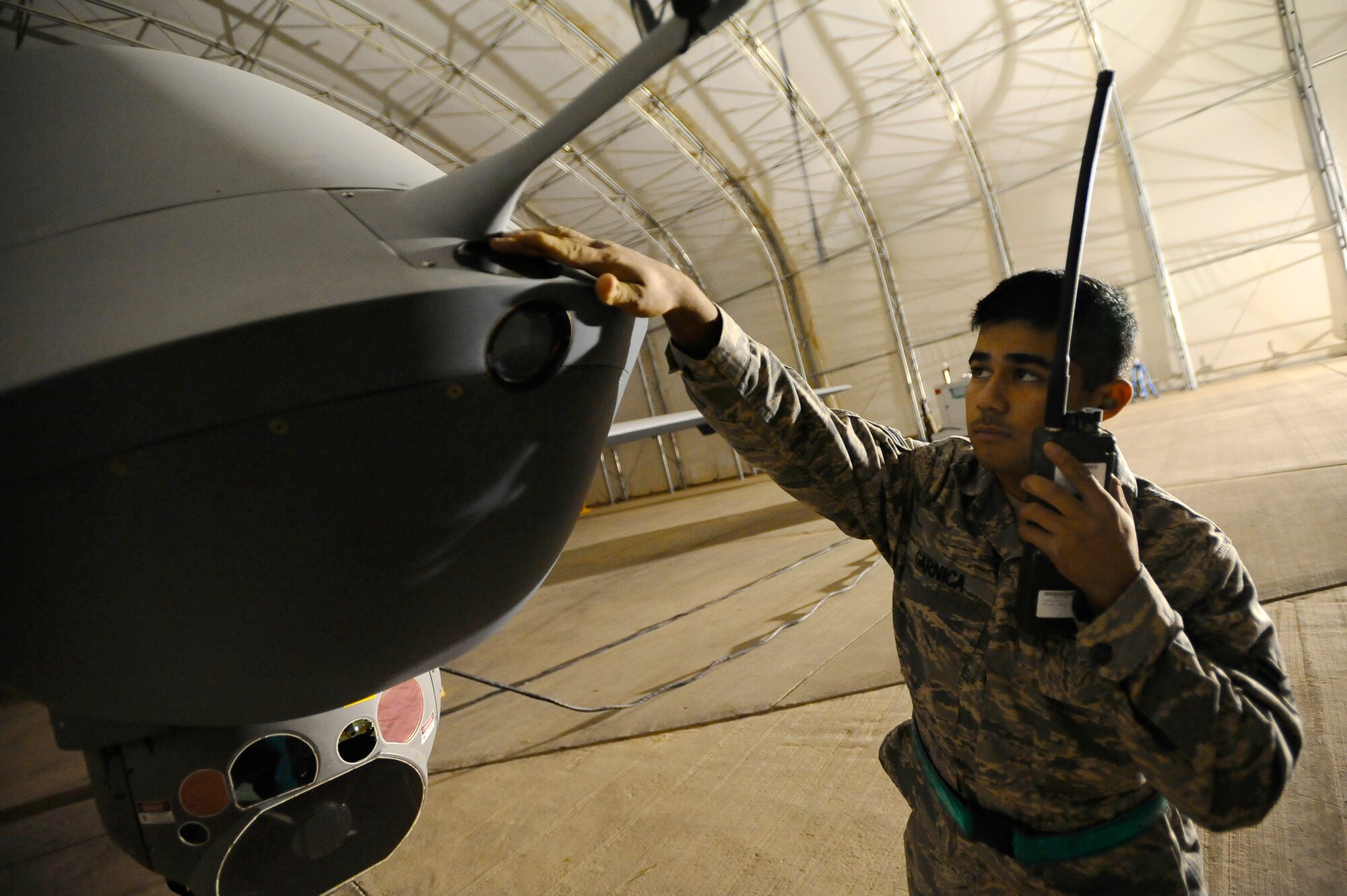 Airman 1st Class Hugo Garnica inspects a lens on an MQ-9 Reaper at Joint Base Balad, Iraq, Nov. 18. He was performing a pre-flight check of the unmanned aircraft vehicle to ensure it was operational. Garnica, an assistant dedicated crew chief assigned to the 332nd Expeditionary Aircraft Maintenance Squadron, is deployed from Creech Air Force Base, Nev. His hometown is Oceanside, Calif. (U.S. Air Force photo/Airman 1st Class Jason Epley)