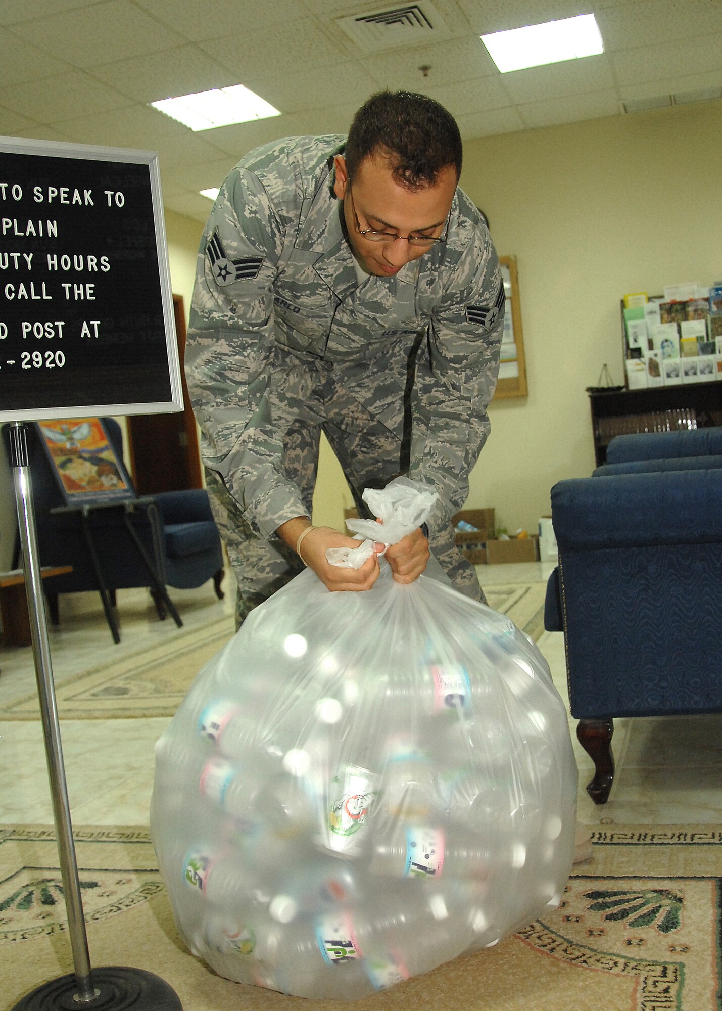 SOUTHWEST ASIA -- Senior Airman Carlos Carlo, 386th Air Expeditionary Wing chaplain assistant, prepares to take a bag of plastic bottles to a recycling bin on Nov. 21 at an air base in Southwest Asia. The 386th Air Expeditionary Wing recycles various items, to include cardboard boxes and plastic bottles. The money that is generated through the recycling program goes back to the base populace for quality of life initiatives and morale, welfare and recreation programs. Airman Carlo is deployed from Hanscom Air Force Base, Mass. (U.S. Air Force photo/Tech. Sgt. Raheem Moore)