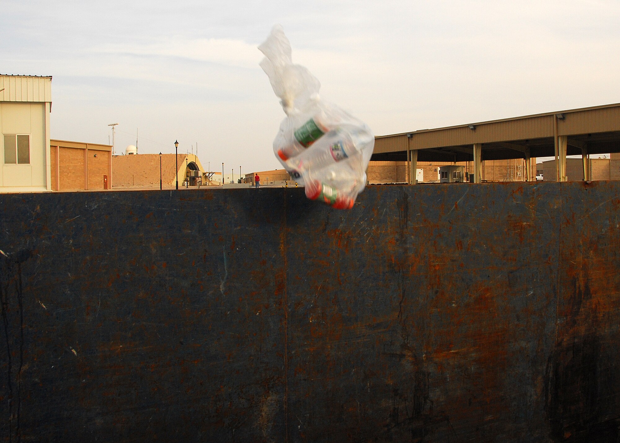 SOUTHWEST ASIA -- A bag of plastic bottles are thrown into a recycling bin on Nov. 15 at an air base in Southwest Asia. The 386th Air Expeditionary Wing recycles various items, to include cardboard boxes and plastic bottles. The money that is generated through the recycling program goes back to the base populace for quality of life initiatives and morale, welfare and recreation programs. (U.S. Air Force photo/Tech. Sgt. Raheem Moore)