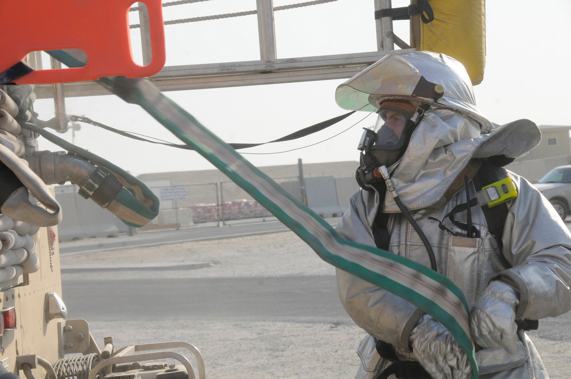 Tech. Sgt. Peter W. Peterson, firefighter crew chief assigned to the 379th Expeditionary Civil Engineer Squadron, pulls out hose as part of crew proficiency training Nov. 20, at an undisclosed air base in Southwest Asia. Daily crew proficiency training ensures these ECES members are prepared for any situation. Sergeant Peterson, a native of Minneapolis, Minn., is deployed from Whiteman Air Force Base, Mo., in support of Operations Iraqi and Enduring Freedom and Joint Task Force-Horn of Africa. (U.S. Air Force photo by Staff Sgt. Darnell T. Cannady/Released)