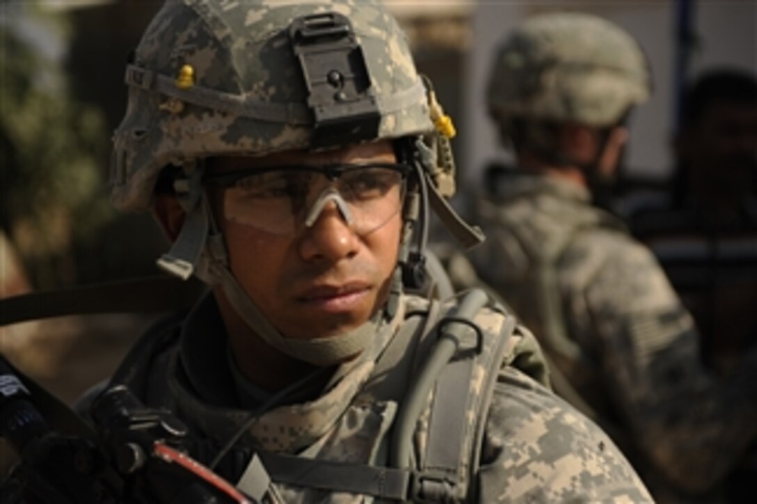 U.S. Army Staff Sgt. Henry Flores III, with 2nd Battalion, 8th Infantry Regiment, 2nd Brigade Combat Team, 4th Infantry Division, provides security as soldiers patrol Diwaniyah, Iraq, to assess area markets and residents' needs on Nov. 13, 2008.  