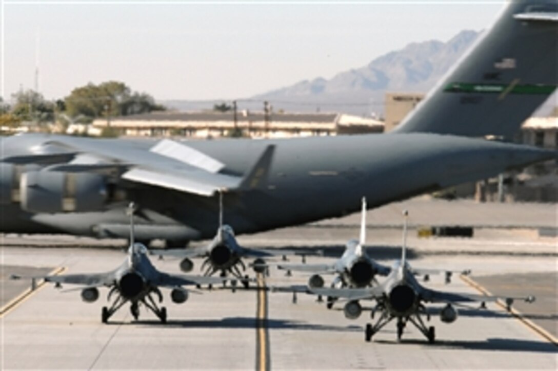 A C-17 Globemaster III taxis past a group of F-16 Fighting Falcons during the Mobility Air Forces Exercise at Nellis Air Force Base, Nev., Nov. 19, 2008. The exercise tests the ability of airlift crews from 12 bases to join together at a specific time and location to drop a brigade-size force anywhere in the world.