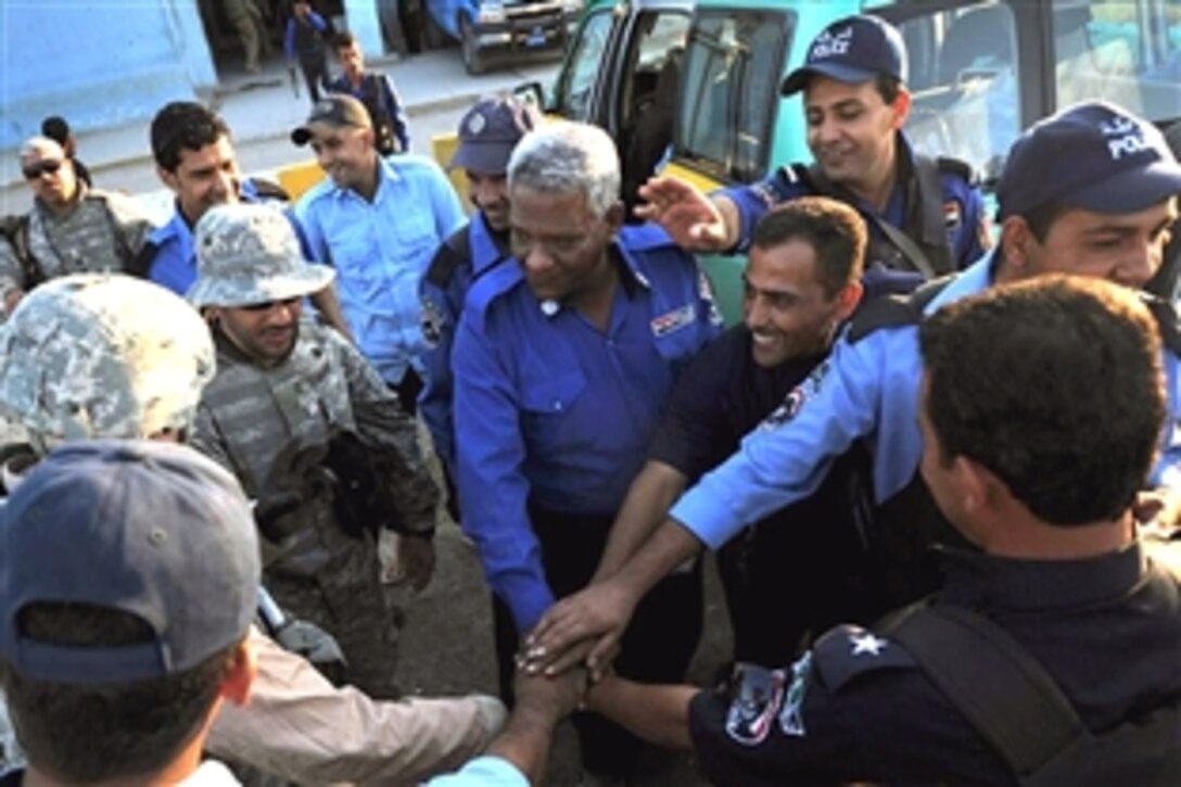 U.S. Airmen shake hands with Iraqi police prior to leaving the Al-Amil Iraqi Police Station within the Al-Baya'a community located in southern Baghdad, Iraq, Nov. 14, 2008. The airmen are assigned to Detachment 3, 732nd Expeditionary Security Forces Squadron, 1st Brigade Combat Team, 4th Infantry Division.