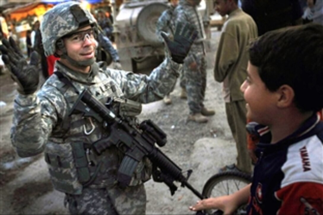 U.S. Army Sgt. Jason Brown entertains Iraqi children during a break while on a walking patrol within the Shurta Market in the Al-Baya'a community located in southern Baghdad, Iraq, Nov. 14, 2008. Brown is assigned to the 1st Brigade Combat Team, 4th Infantry Division.