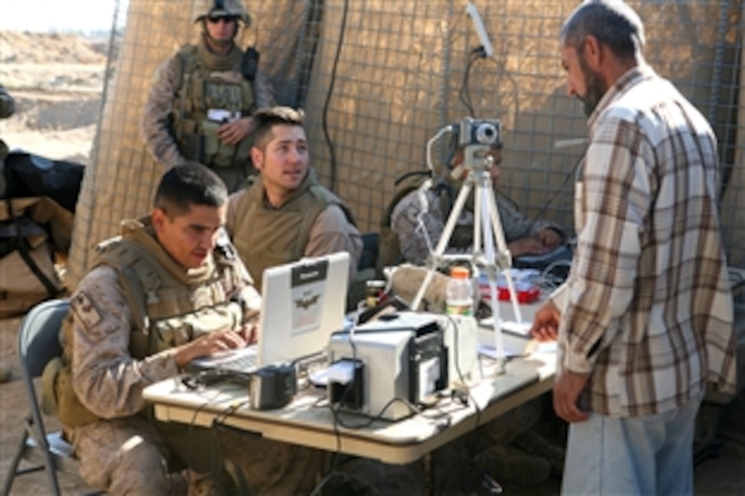 Marines assigned to Company C, 1st Battalion, 4th Marine Regiment, take photos of civilians during a remote badging operation at the Abuyuset area of Iraq, Nov. 8, 2008. ID cards were issued that day and civilian information was entered into the Biometrics Automated Toolset system.
