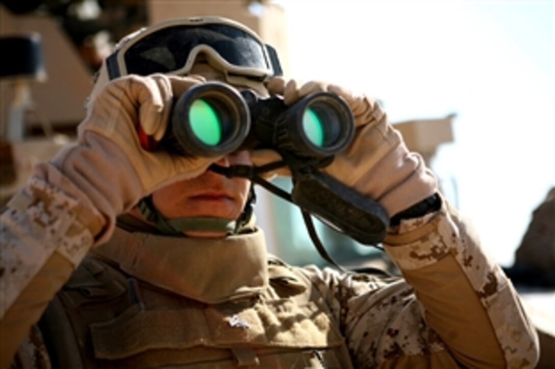 U.S. Marine Corps Cpl. Jason D. Calo observes the location of mortar round hits during a Tactical Air Control Party training exercise, Nov. 13, 2008, in al Anbar Province, Iraq. Calo was responsible for spotting and relaying coordinates of mortar hits to both the mortar teams and forward air controllers to ensure the aircrafts had the correct targets. Calo is an artillery/mortar scout assigned to 2nd Battalion, 9th Marine Regiment.