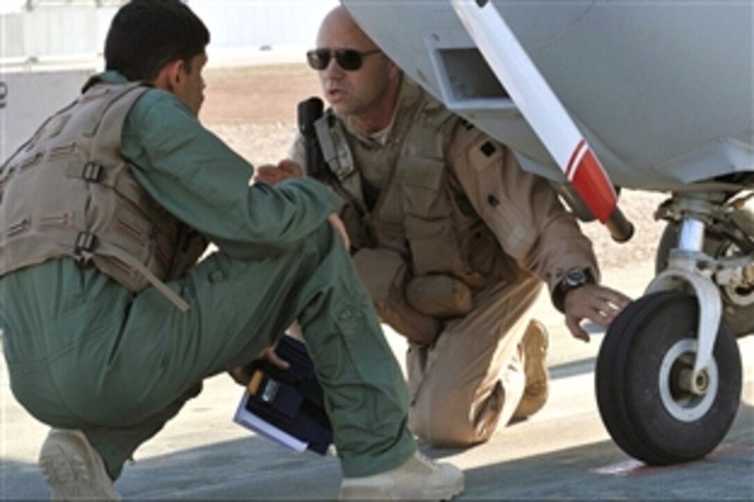 U.S. Air Force Capt. Christopher Duffett makes sure his trainee inspects each required section of his plane before a training flight on Forward Operating Base Warrior, Kirkuk, Iraq, Nov. 10, 2008. Duffett is a flight instructor and assigned to the 52nd Expeditionary Flight Squadron. 
The squadron is training Iraqi Air Force flight trainees.