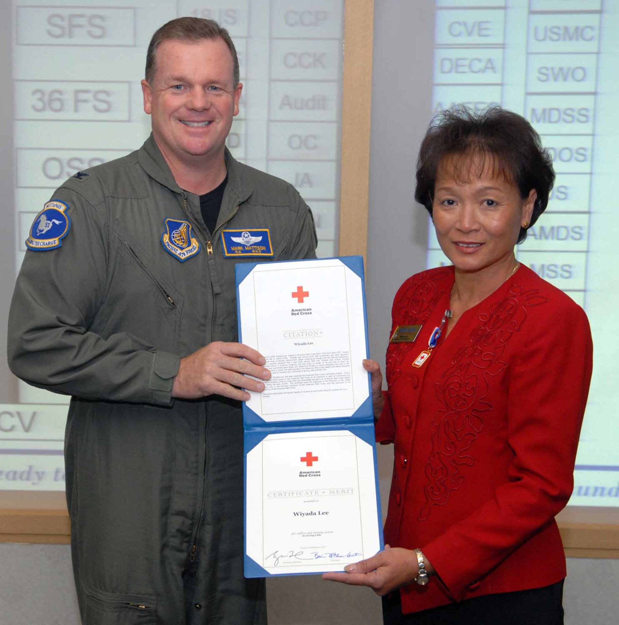 Col. Mark Mattison, 51st Fighter Wing vice commander, presents Wiyada Lee, Osan’s director of youth programs, with the American Red Cross Certificate of Merit. Ms. Lee was recognized for the heroic actions she took on April 2, 2008, when she saved a co-worker’s life. (U.S. Air Force photo/Senior Airman Christopher Boitz)