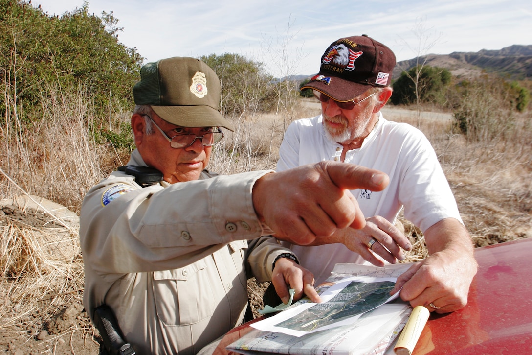 Frank R. Hernandez, federal game warden, Marine Corps Base Camp Pendleton, helps a former service member find authorized recreational areas while looking at maps provided by the base.