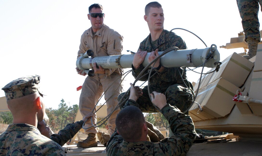 Marines with 2nd Combat Engineers Battalion mount a rocket onto an Assault Breacher Vehicle here, Nov. 24, which will be used to launch a line charge for the first time since the ABV came to the fleet. The line charge, a long string of C4 explosives attached to a rocket, is used to clear a lane of all mines or improvised explosive devices so that tanks and other large equipment have a safe path to navigate on. (Official Marine Corps Photo by Lance Cpl. Brian M. Woodruff) (RELEASED)