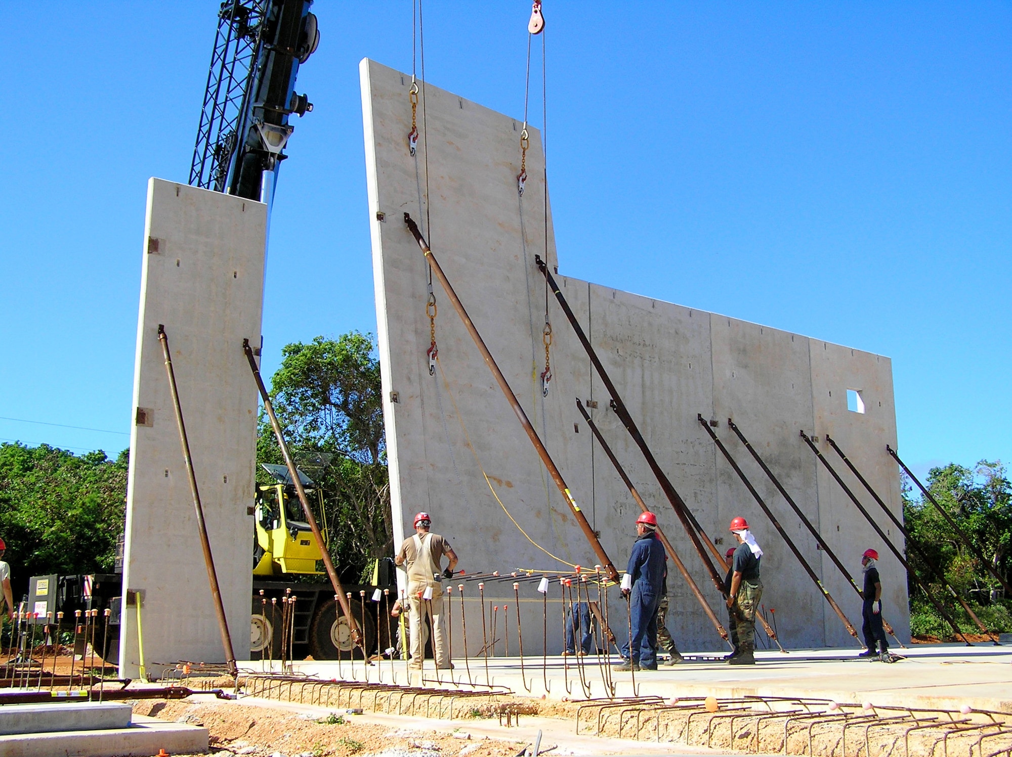 ANDERSEN AIR FORCE BASE, Guam -- 554th REDHORSE Squadron members guide a concrete slab into place during the tilt-up constuction process. The tilt-up construction process has been around since the early 1900s. The 554th RHS discovered that the tilt-up construction method was the the best construction technique for Guam, and underwent training to become proficient in the area, bringing tilt-up construction to Andersen. (U.S. Air Force photo by Capt. April Bowman)      