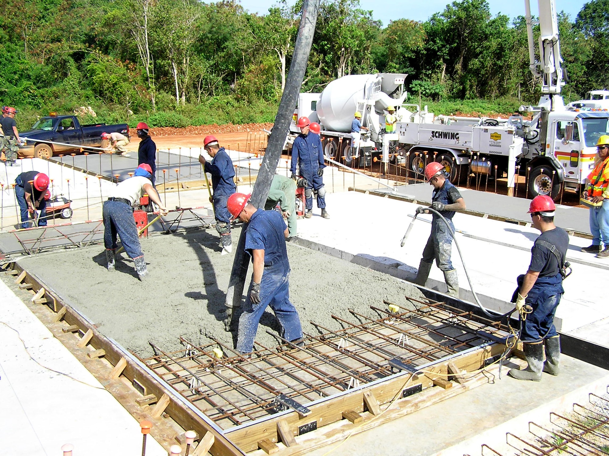 ANDERSEN AIR FORCE BASE, Guam -- 554th REDHORSE Squadron members pour concrete onto a rebar frame to make a durable concrete slab, ready to be used once dry for the tilt-up construction process. The tilt up construction process helps to conserve Guam's natural resources. (U.S. Air Force photo by Capt. April Bowman)