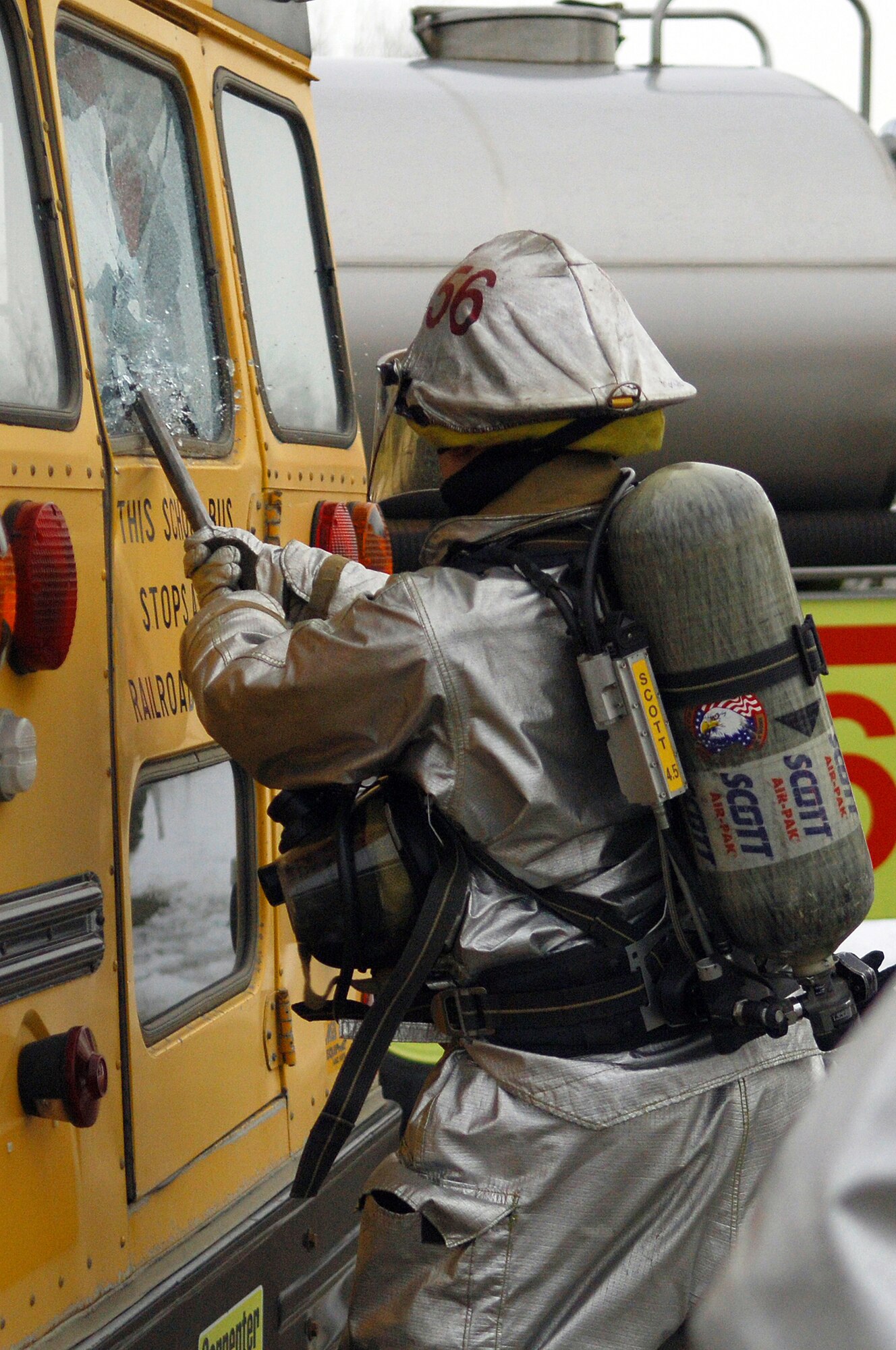 MINOT AIR FORCE BASE, N.D. – Senior Airman Scott Morsette, 5th Civil Engineer Squadron firefighter, breaks a school bus window in an effort to retrieve “casualties” during a simulated accident between the bus and a fire engine during a major accident response exercise (MARE) here Nov. 18. The MARE is used to test the response capabilities of the base’s emergency response teams during inclement weather conditions. (US Air Force Photo by Senior Airman Cassandra Jones)