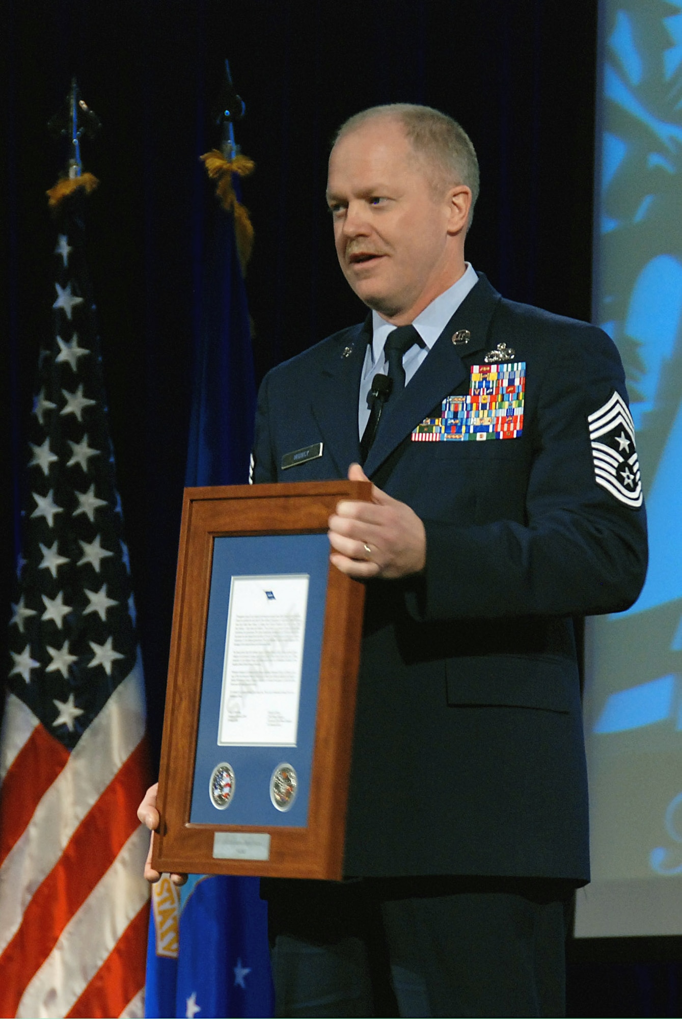 Chief Master Sgt. Christopher Muncy holds up a Hometown Heroes Salute Award that will be given in 2009 to eligible National Guard Airmen who deployed on orders for more than 30 consecutive days in a contingency operation. Chief Muncy, the command chief of the Ohio Air National Guard, and Chief Master Sgt. Richard Smith, command chief of the Air Guard, announced the Hometown Heroes Salute program Nov. 20 at the Air Guard Senior Leadership conference outside Washington. (U.S. Air Force photo/Master Sgt. Mike R. Smith) 
