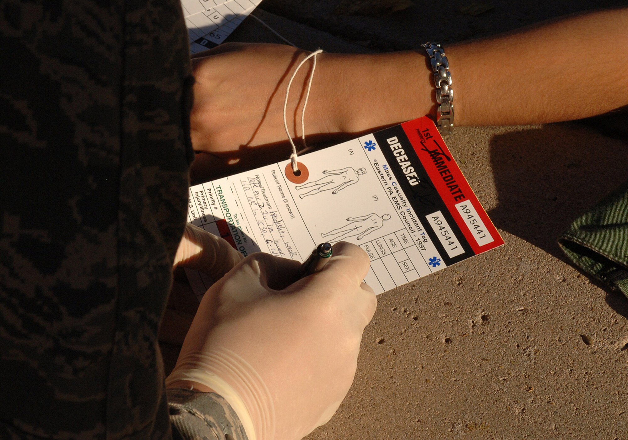 An Airman from the 49th Medical Group fills out a Mass Caualty Incident Tag after a simulated explosion on Holloman Air Force Base, N.M., Nov. 20. The Airmen were participating in a week-long exercise, Coronet Gold Rush 08-08, to test their skills in the most realistic manner possible. (U.S. Air Force photo/Airman 1st Class Michael Means)
