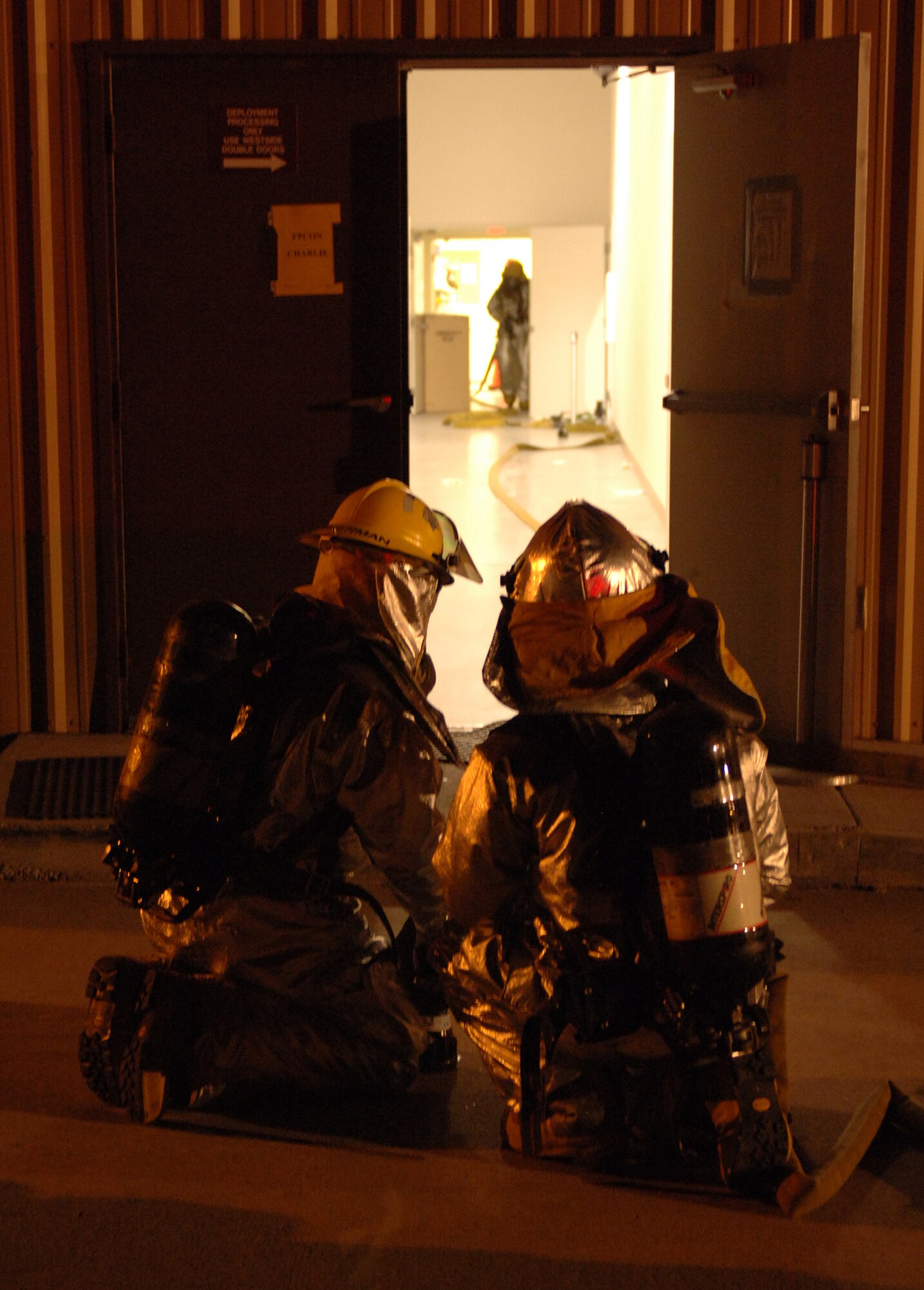 Airmen from the 49th Civil Engineer Squadron Fire Department respond to a simulated building fire at Holloman Air Force Base, N.M., Nov. 20. The Airmen were participating in a week-long exercise, Coronet Gold Rush 08-08, to test their skills in the most realistic manner possible. (U.S. Air Force photo/Airman 1st Class Michael Means)