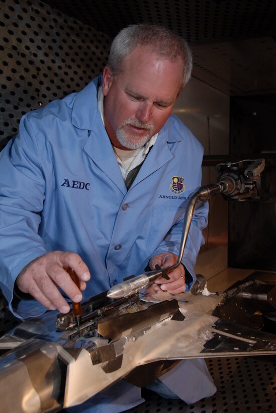 Aerospace Testing Alliance Outside Machinist Jim Lynch makes adjustments to a model of a GBU-31 Joint Direct Attack Munition (JDAM) before F-35 Lightning II store separation testing resumed in Arnold Engineering Development’s (AEDC) four-foot transonic wind tunnel. (Photo by Rick Goodfriend)