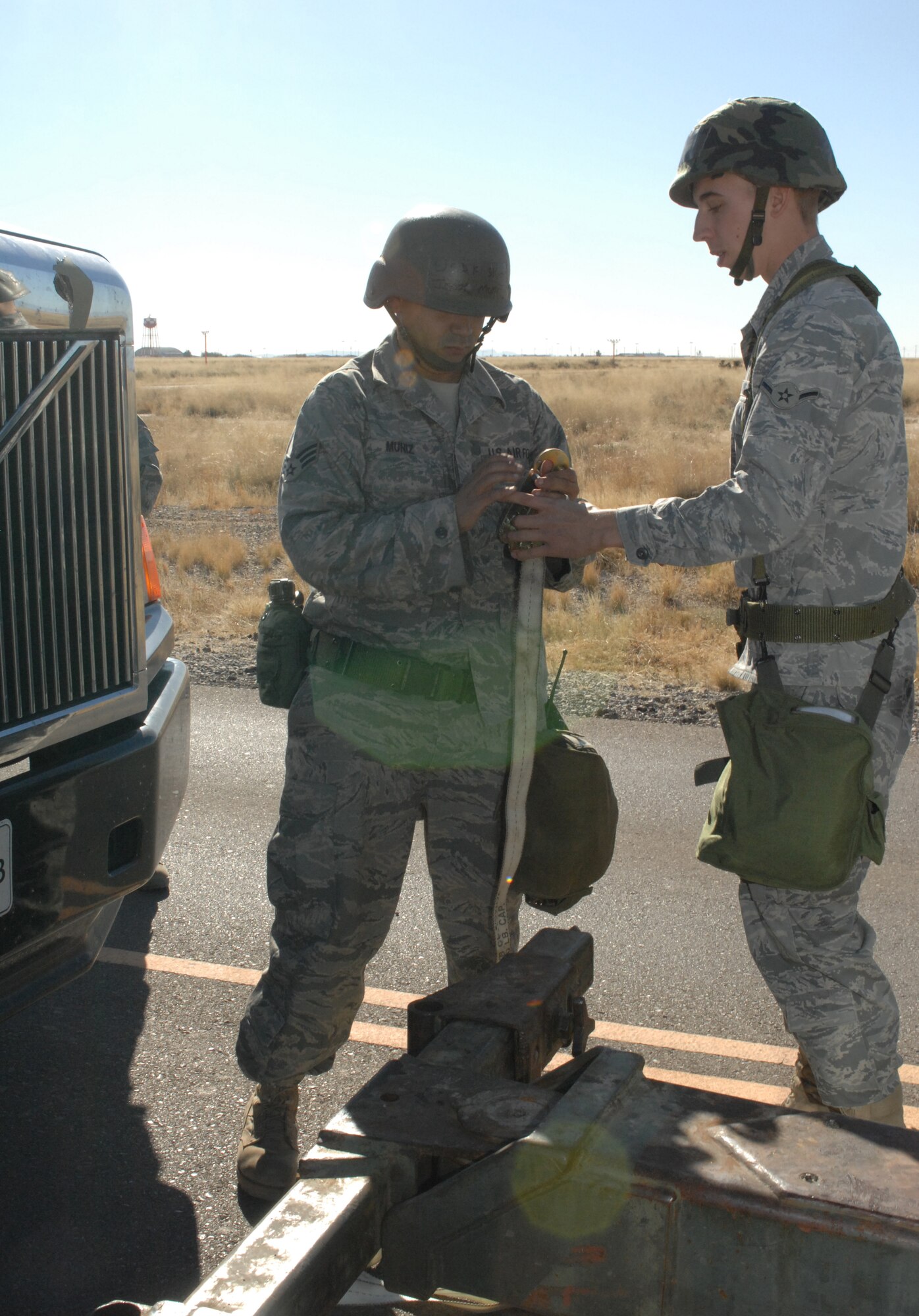 Senior Airman Israel Muniz and Airman Travis Ogburn, both from the 49th Logistics Readiness Squadron, are about to perform a "hasty recovery" on a tracker that was damaged by a simulated improvised explosive device during a phase II exercise at Holloman Air Force Base, N.M., Nov. 20. (U.S. Air Force photo/Airman Sondra M. Escutia)