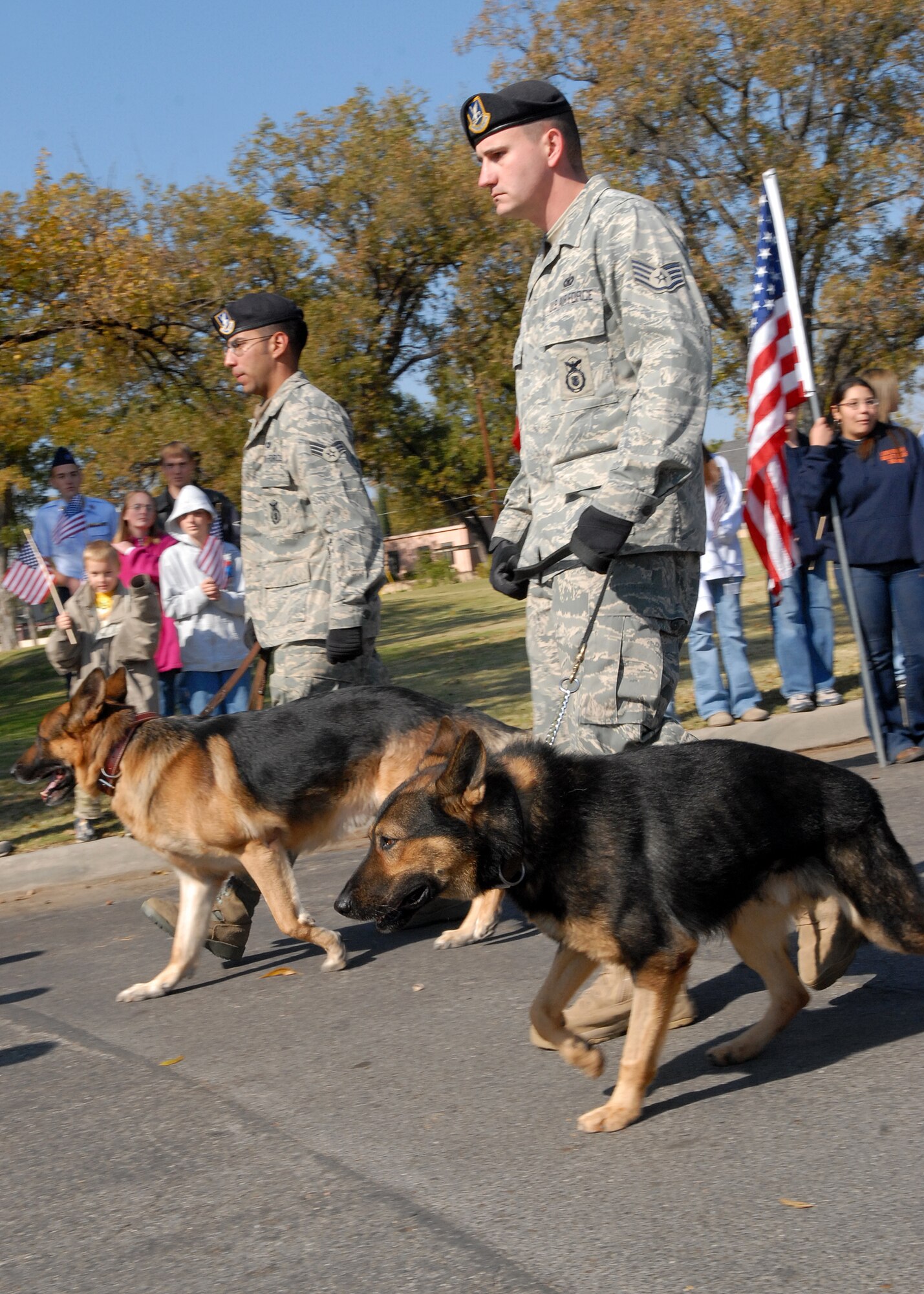 Staff Sgt. Dustin Vigil (front) and Senior Airman Nathan Escobar, two 17th Security Forces Squadron military working dog handlers, walk with their dogs in the Hunt for Heroes parade through downtown San Angelo on Nov. 21.  The parade gave members of the Goodfellow and San Angelo communities the opportunity to come out and show support for the wounded warriors who were participating in the hunt.  (U.S. Air Force photo by Senior Airman Kasabyan Musal).