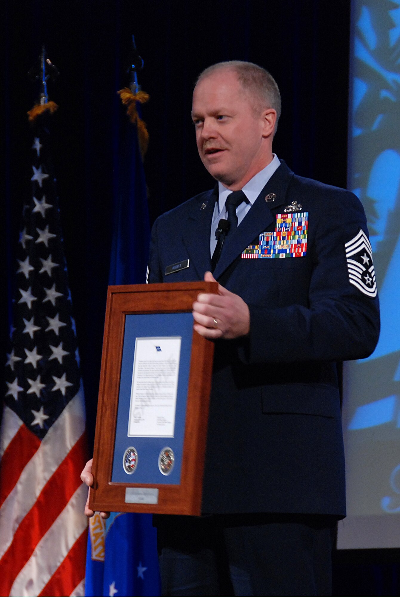 Chief Master Sgt. Christopher Muncy, command chief of the Ohio Air National Guard, holds up a Hometown Heroes Salute award that in 2009 will be given to eligible National Guard Airmen who deployed on orders for more than 30 consecutive days in a contingency operation. Muncy and Chief Master Sgt. Richard Smith, command chief of the Air Guard, announced the Hometown Heroes Salute program Nov. 20 at the Air Guard Senior Leadership conference outside Washington. 
(U.S. Air Force photo by Tech. Sgt. Mike R. Smith) (Released)